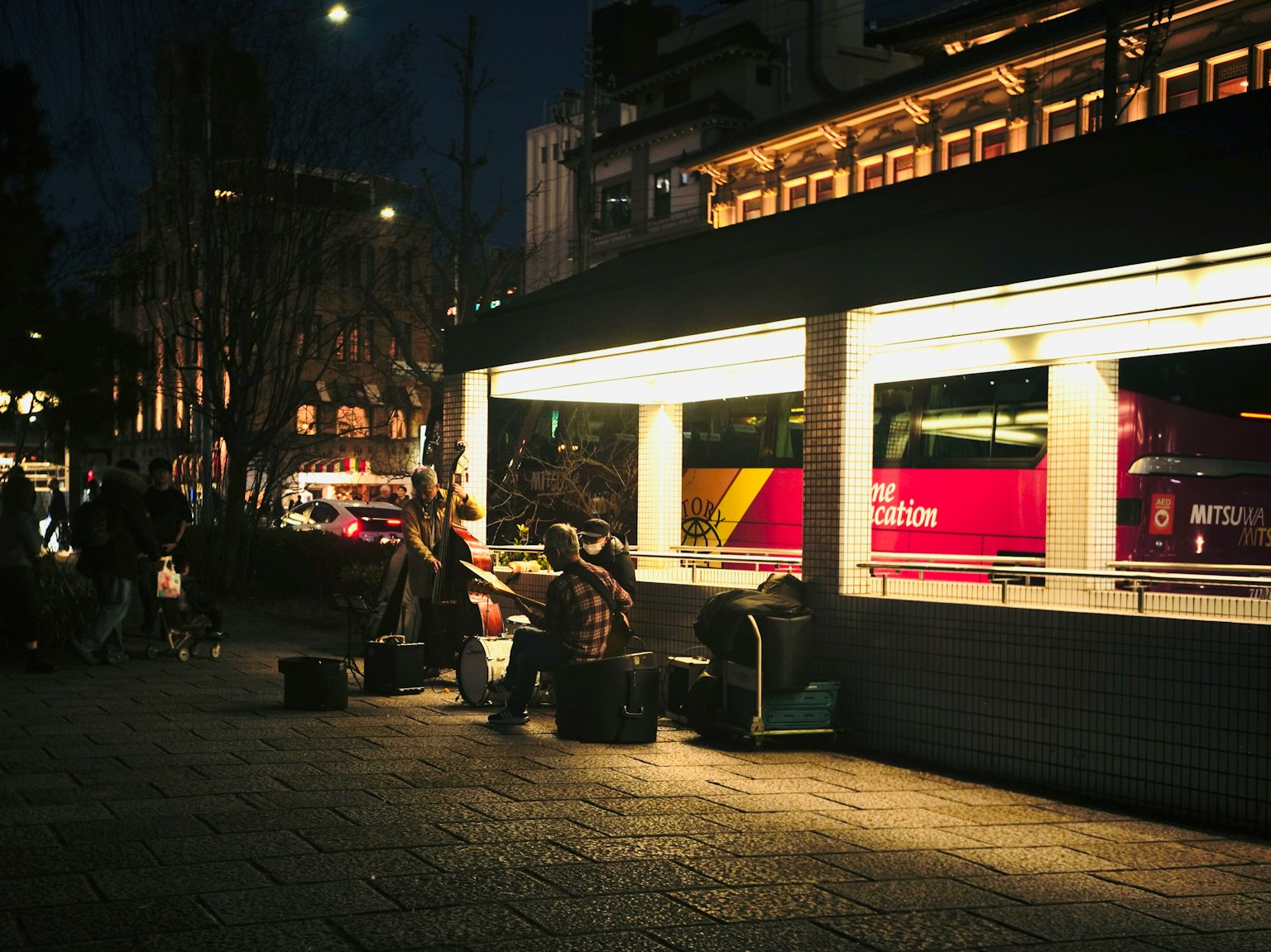 Station de bus la nuit avec des personnes et des lumières