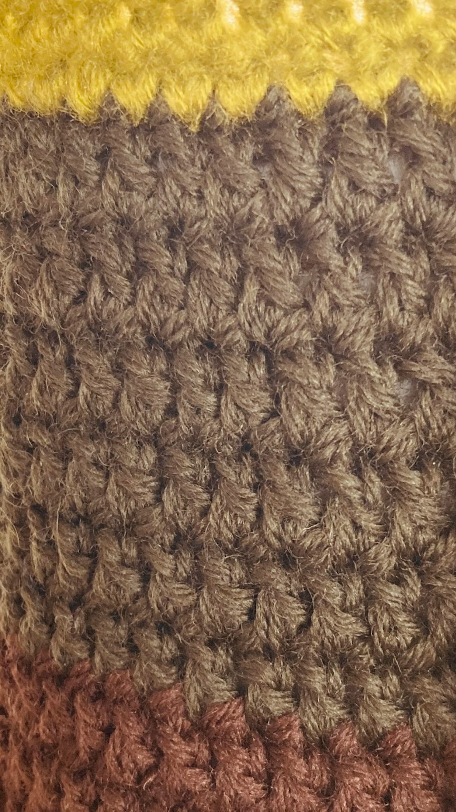 Texturiertes Gewebe, das mit buntem Garn in Gelb, Braun und Grün gestrickt ist