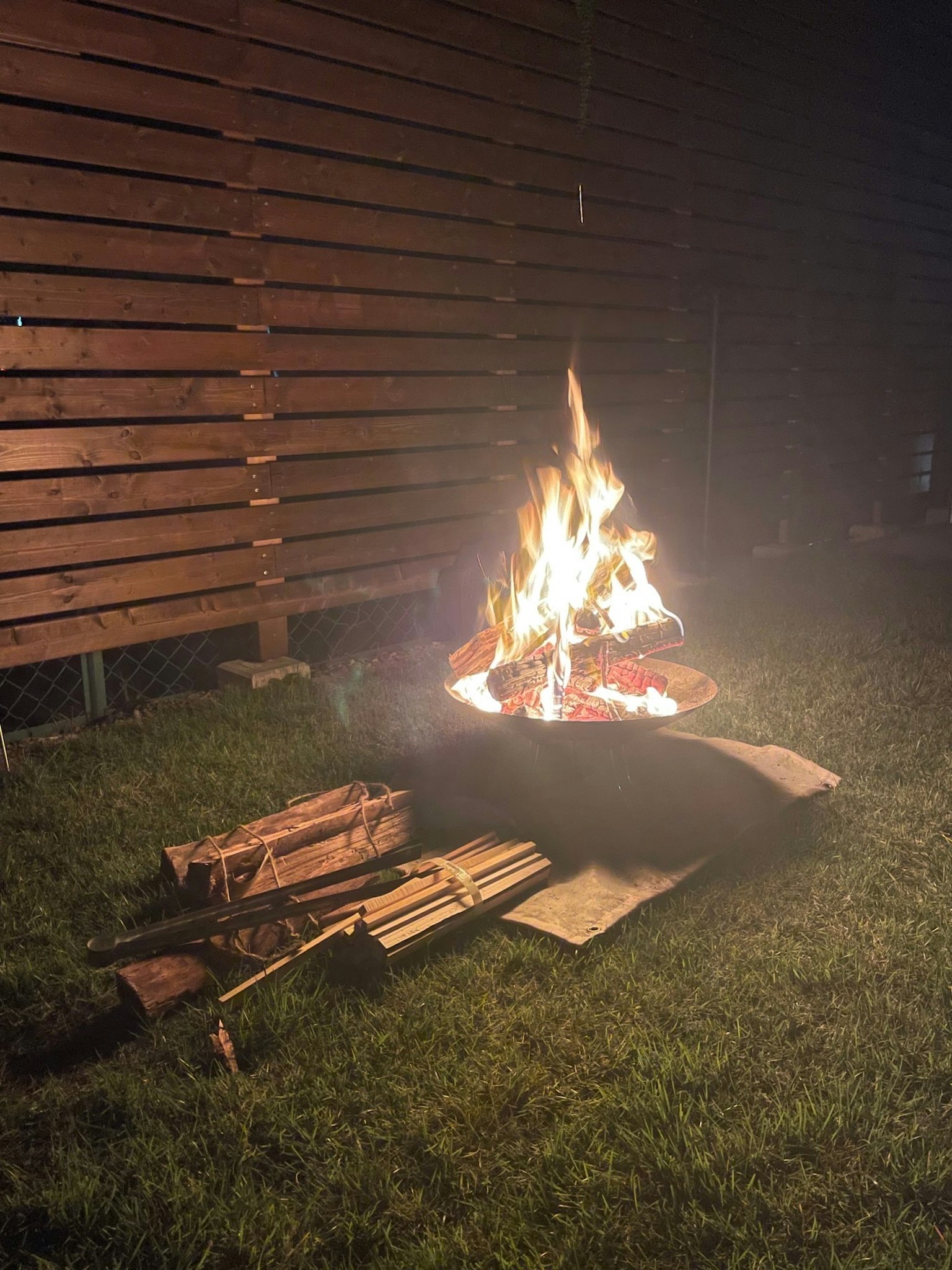 夜间后院燃烧的篝火和堆放的木材