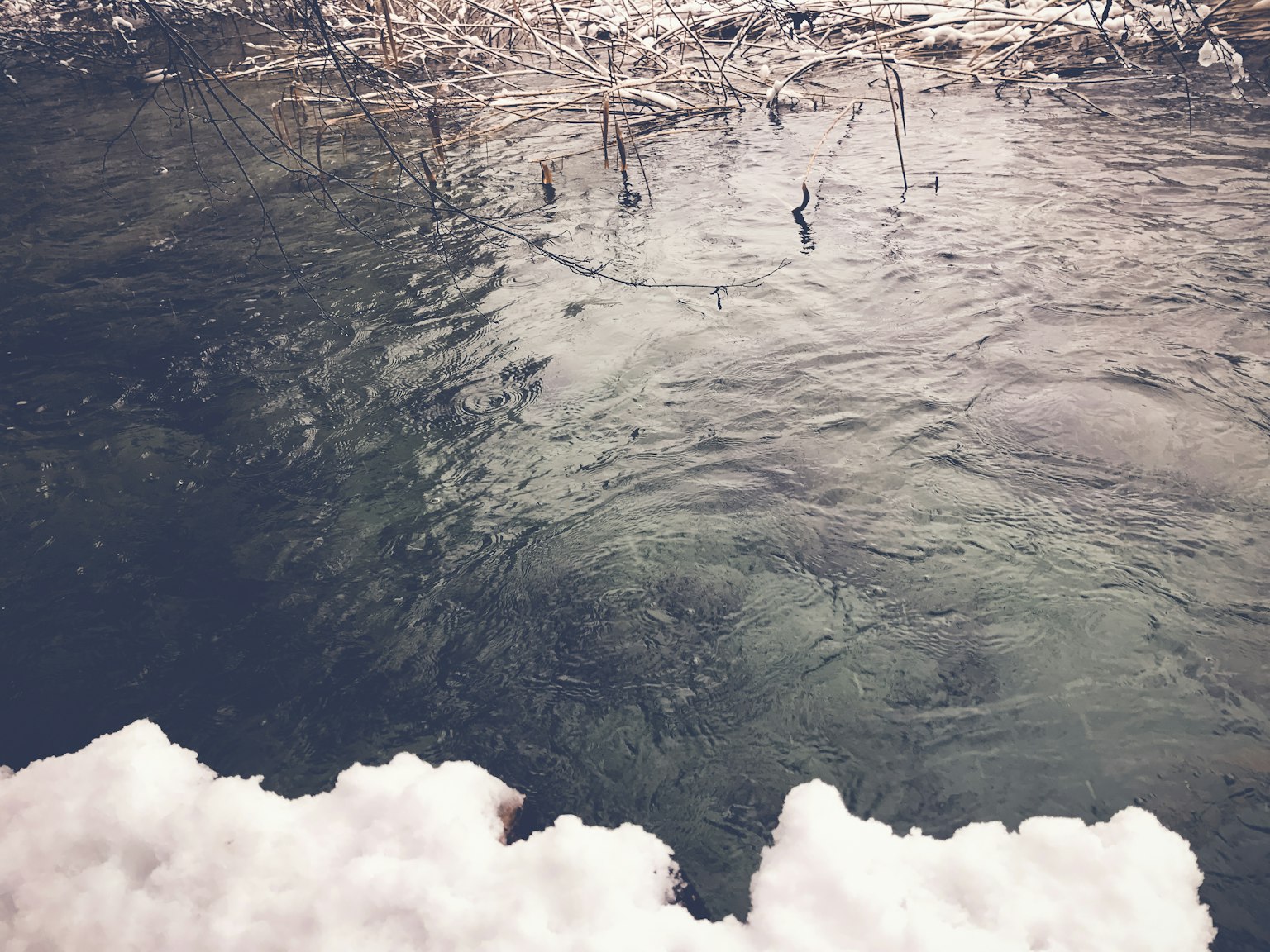 Klare Wasseroberfläche mit Schnee in einer natürlichen Umgebung