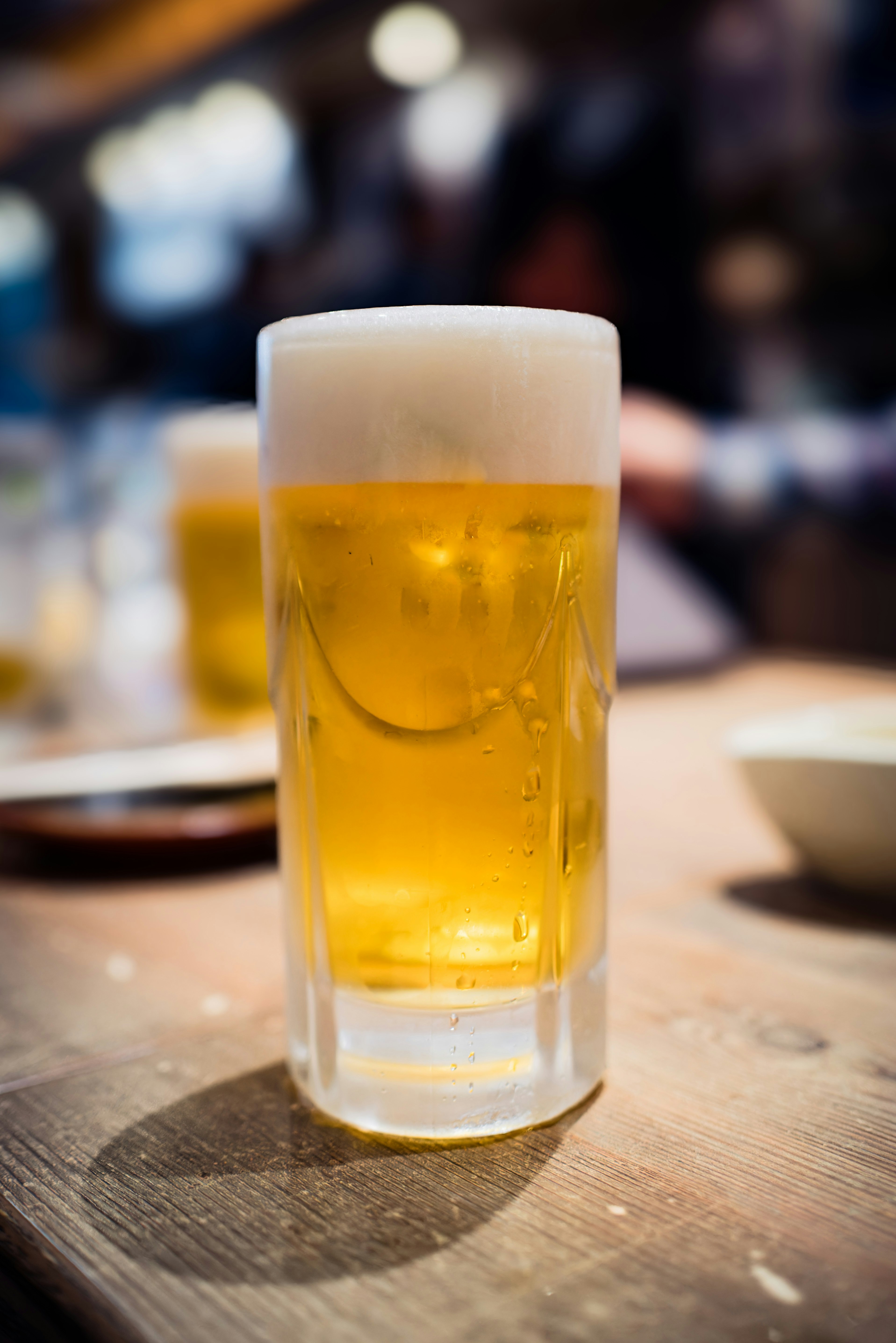 木のテーブルに置かれたビールジョッキのアップ