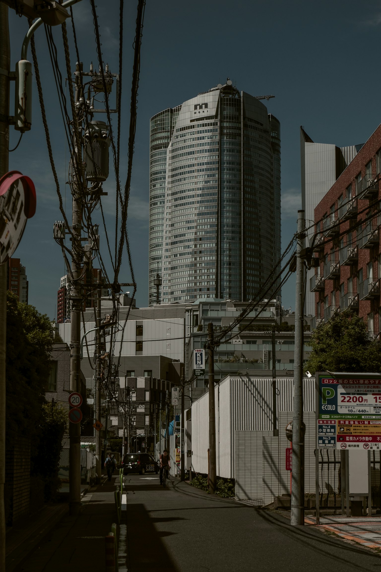 Escena urbana en Tokio con un rascacielos y líneas eléctricas cruzadas