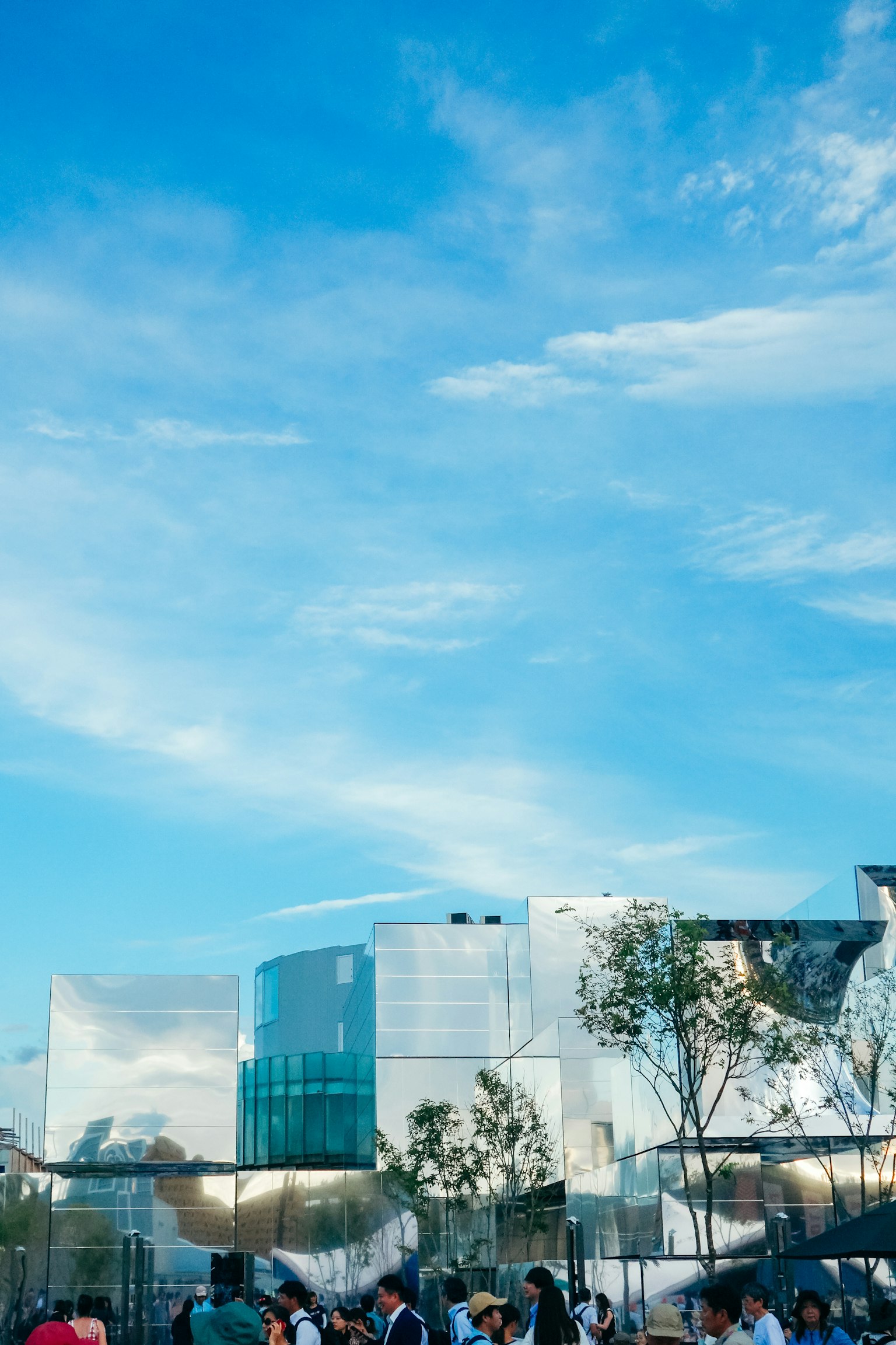 青空の下に現代的な建物が映える風景 人々が集まる公園の一角