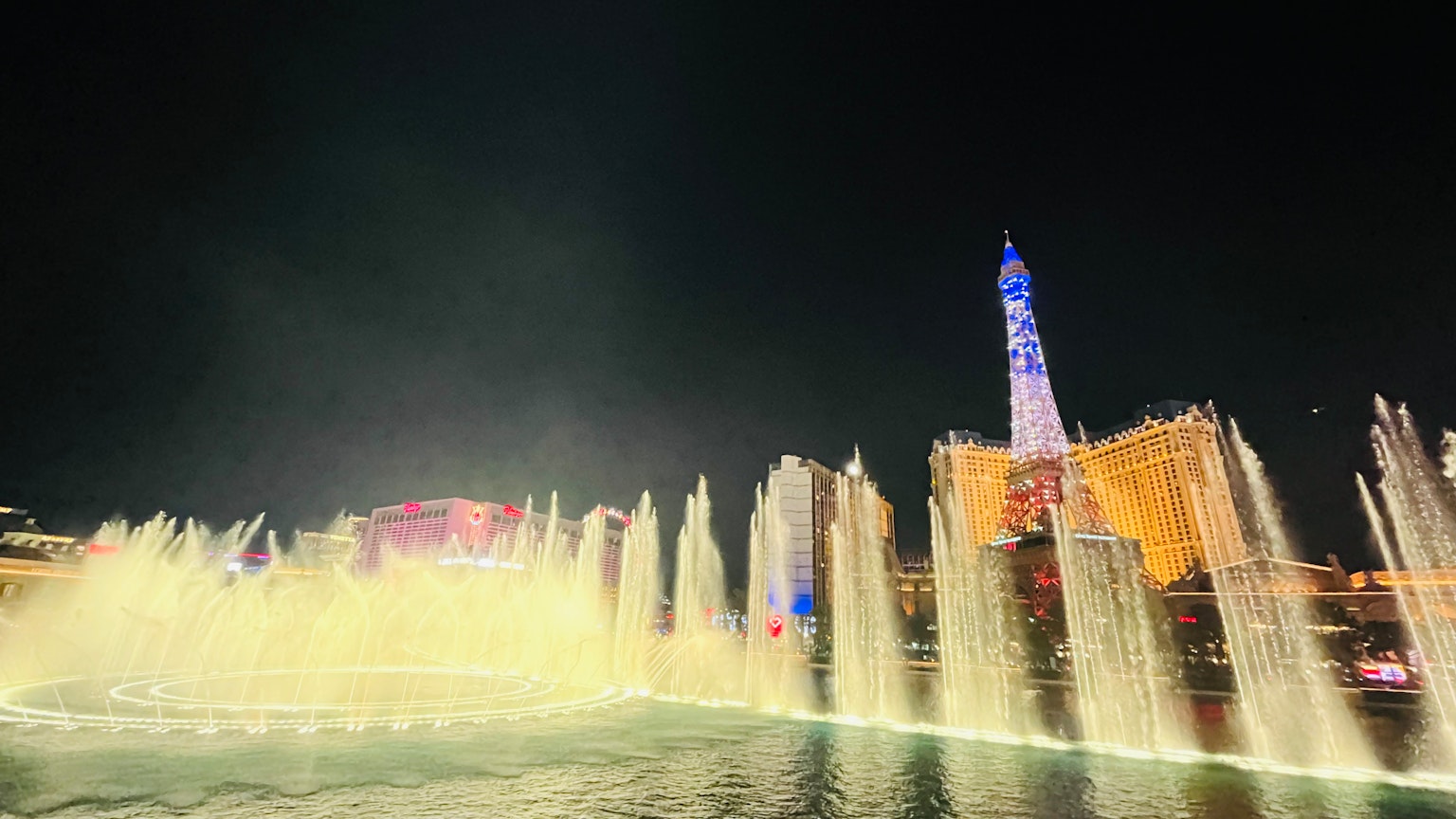 Nächtliche Aussicht auf beleuchtete Brunnen und Gebäude