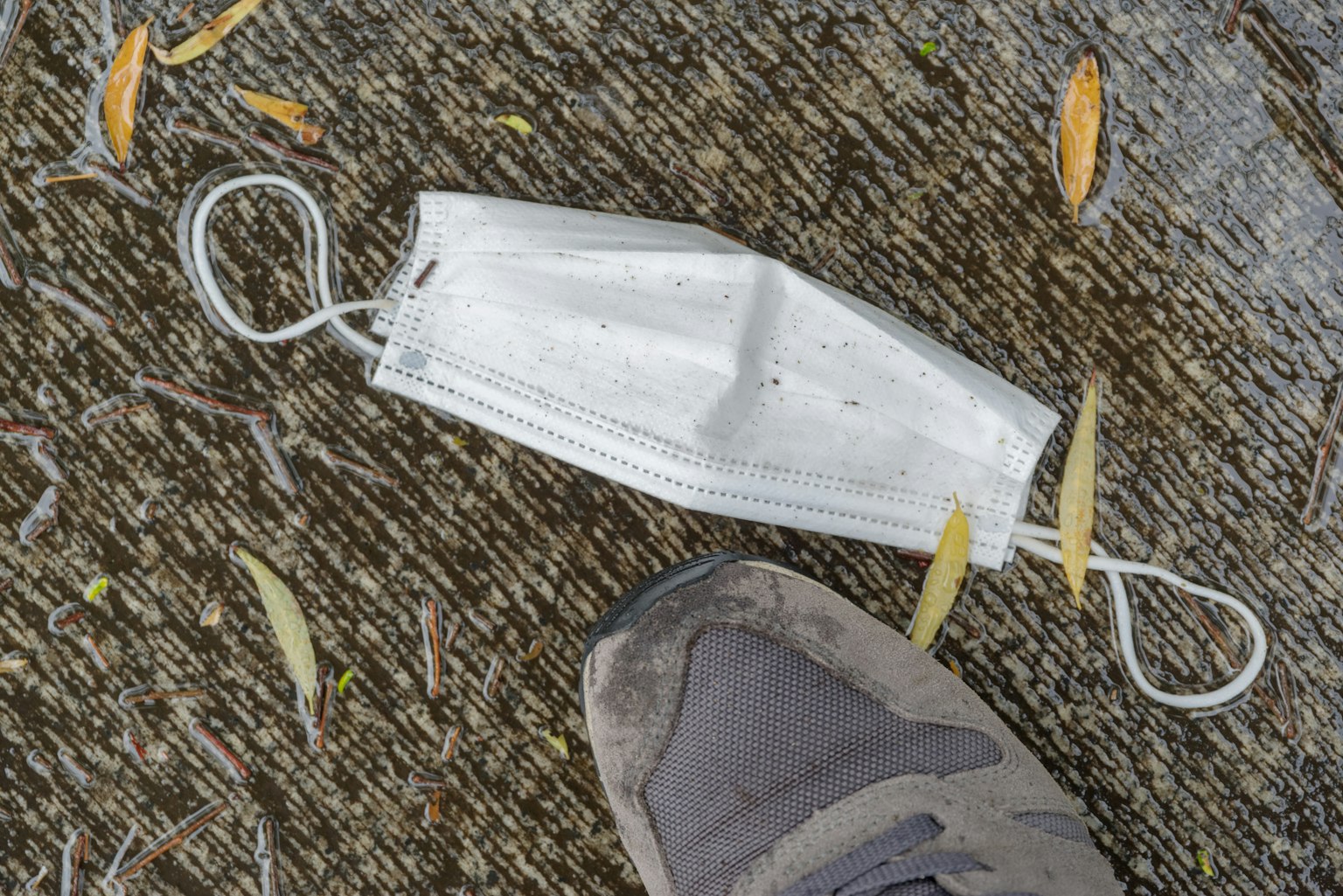 Un masque jeté au sol près d'une chaussure