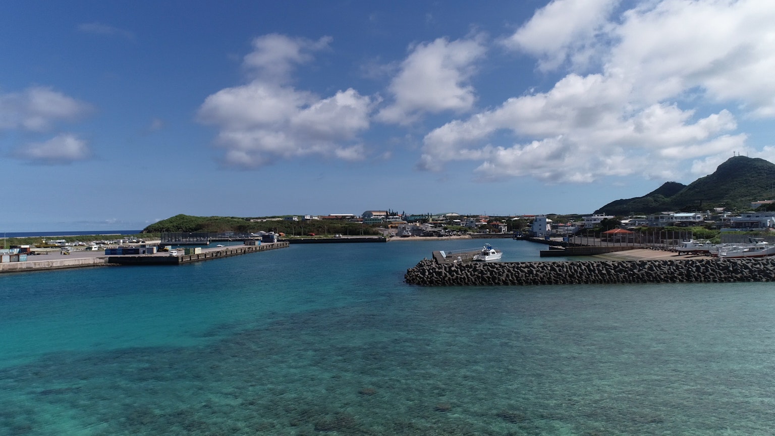 Vista panoramica di un porto con acqua turchese e nuvole bianche