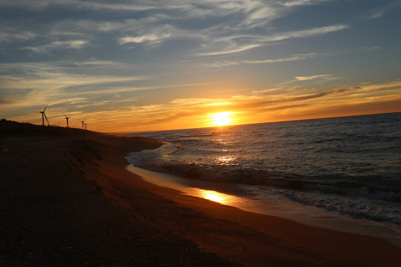 Escena de playa con puesta de sol sobre el océano