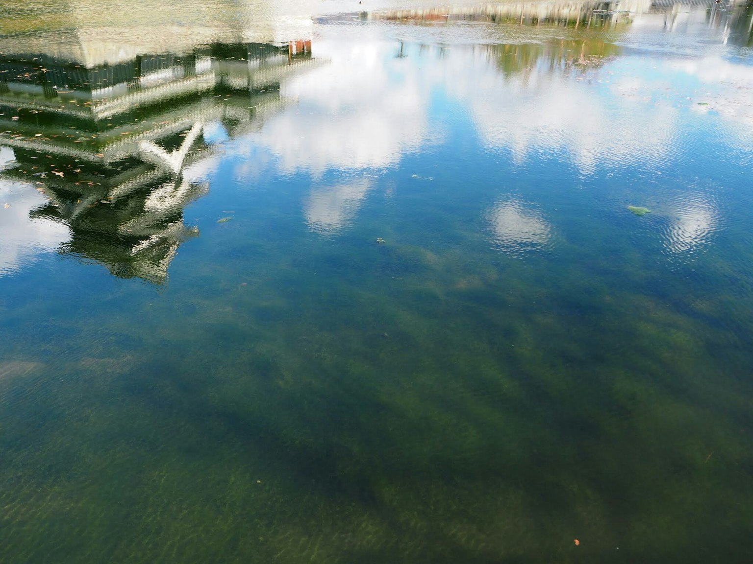 水面上雲和建築物的倒影的寧靜場景