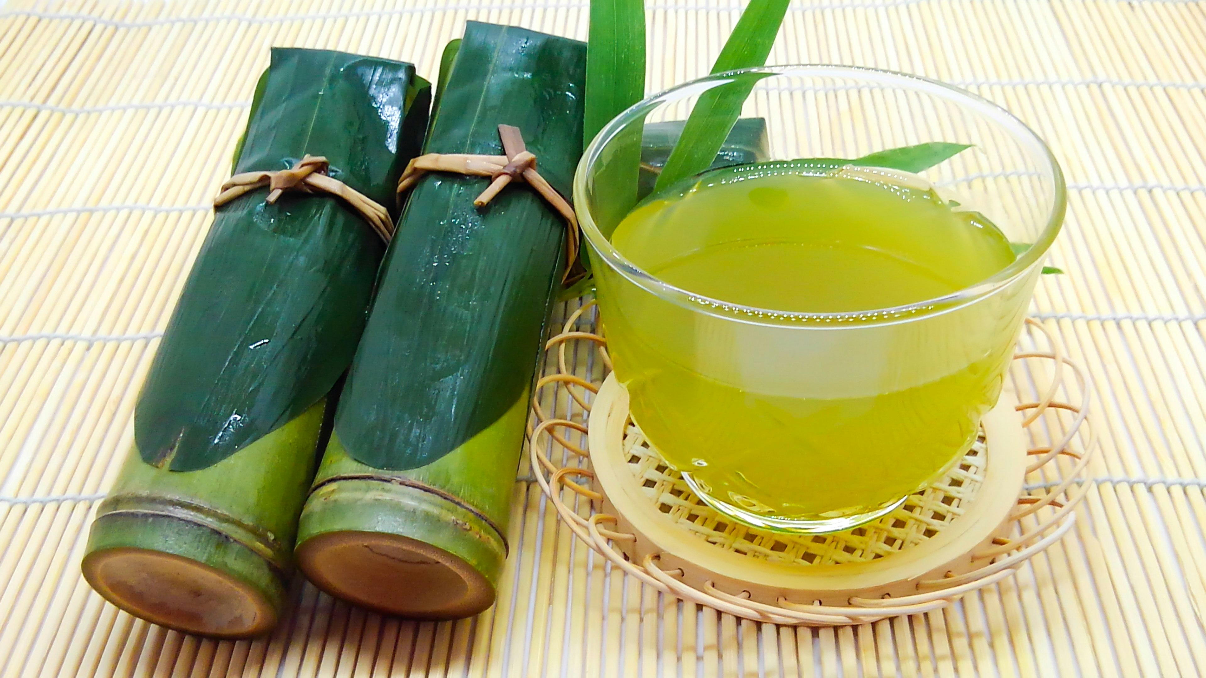 竹筒に入った緑茶と黄色いお茶の入ったガラスカップ