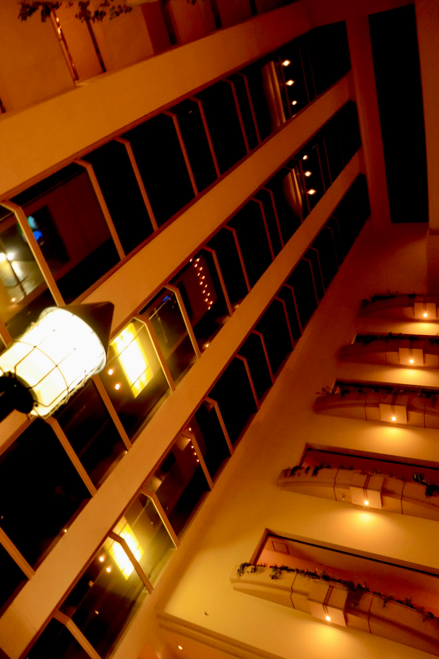 Vue vers le haut à l'intérieur d'un immeuble de grande hauteur avec un éclairage lumineux et des éléments de design moderne