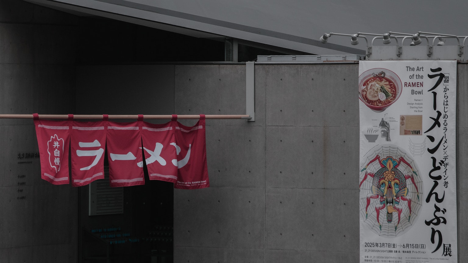 Entrance of a ramen shop with red curtains displaying the word 'ramen'