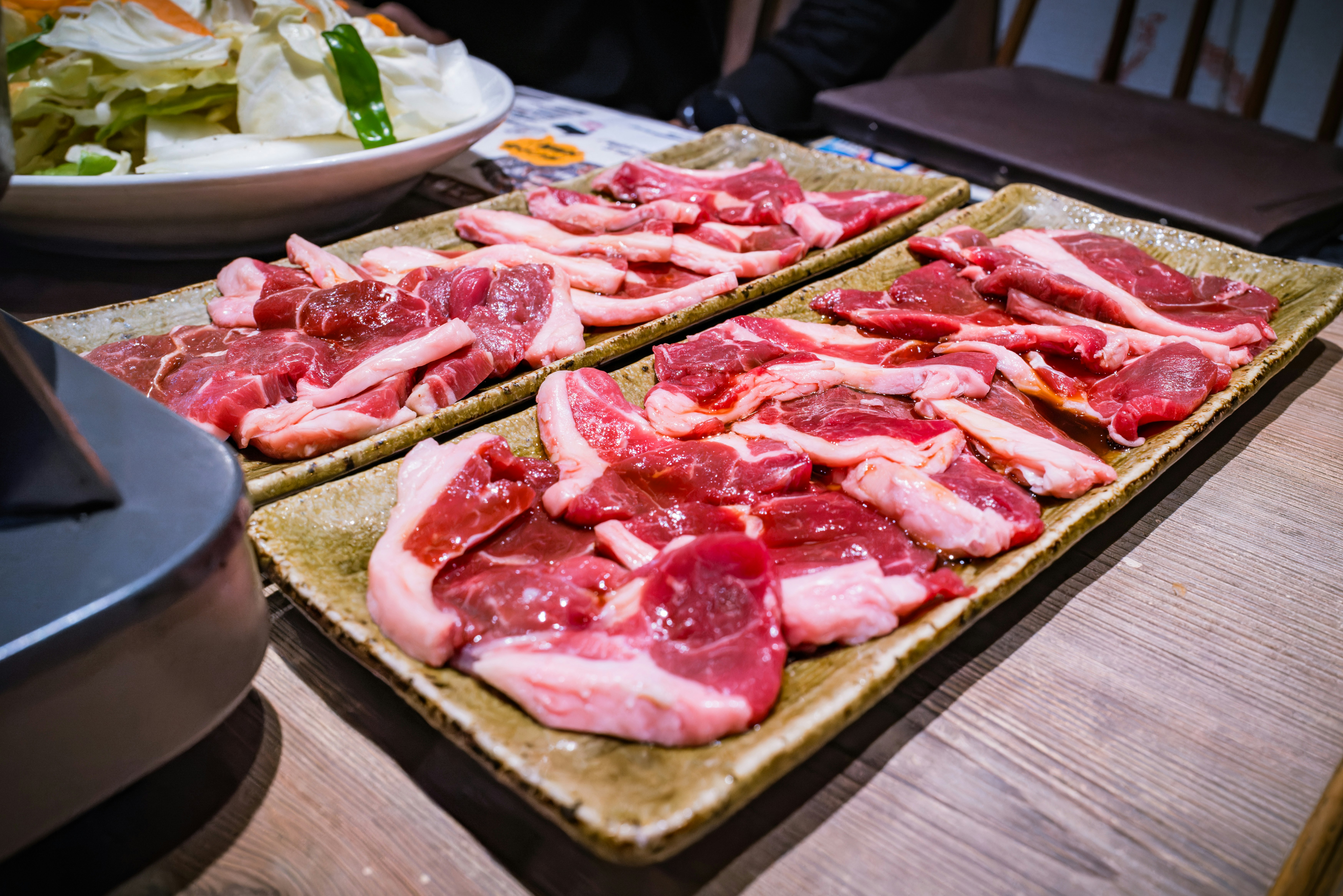assorted raw meat slices on a wooden tray