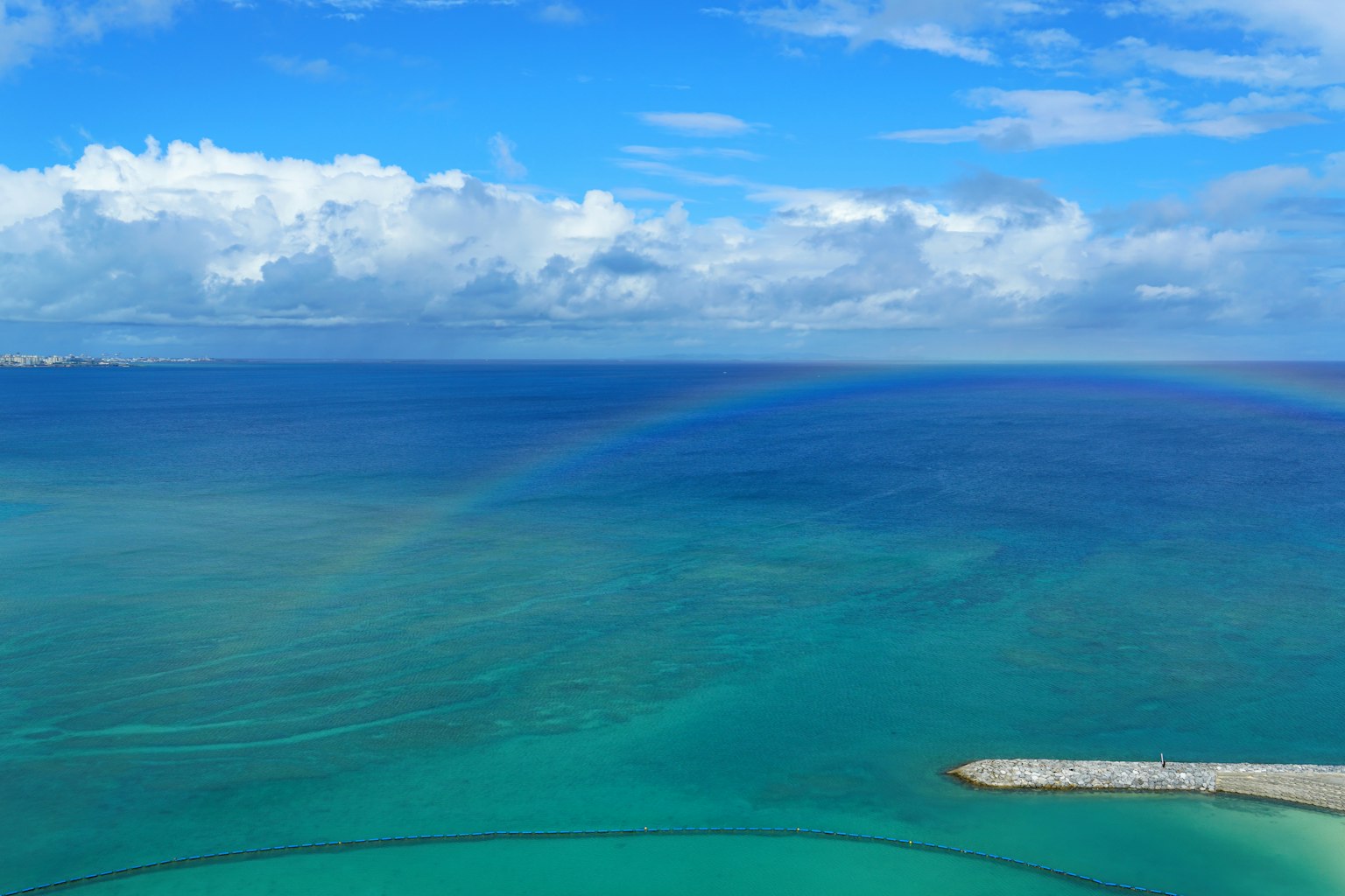 Vibrant blue ocean and sky with a rainbow