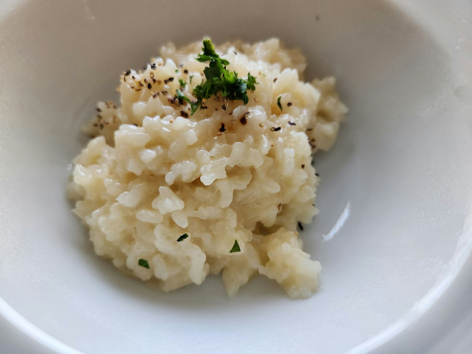 Risotto cremoso guarnito con pepe nero e prezzemolo