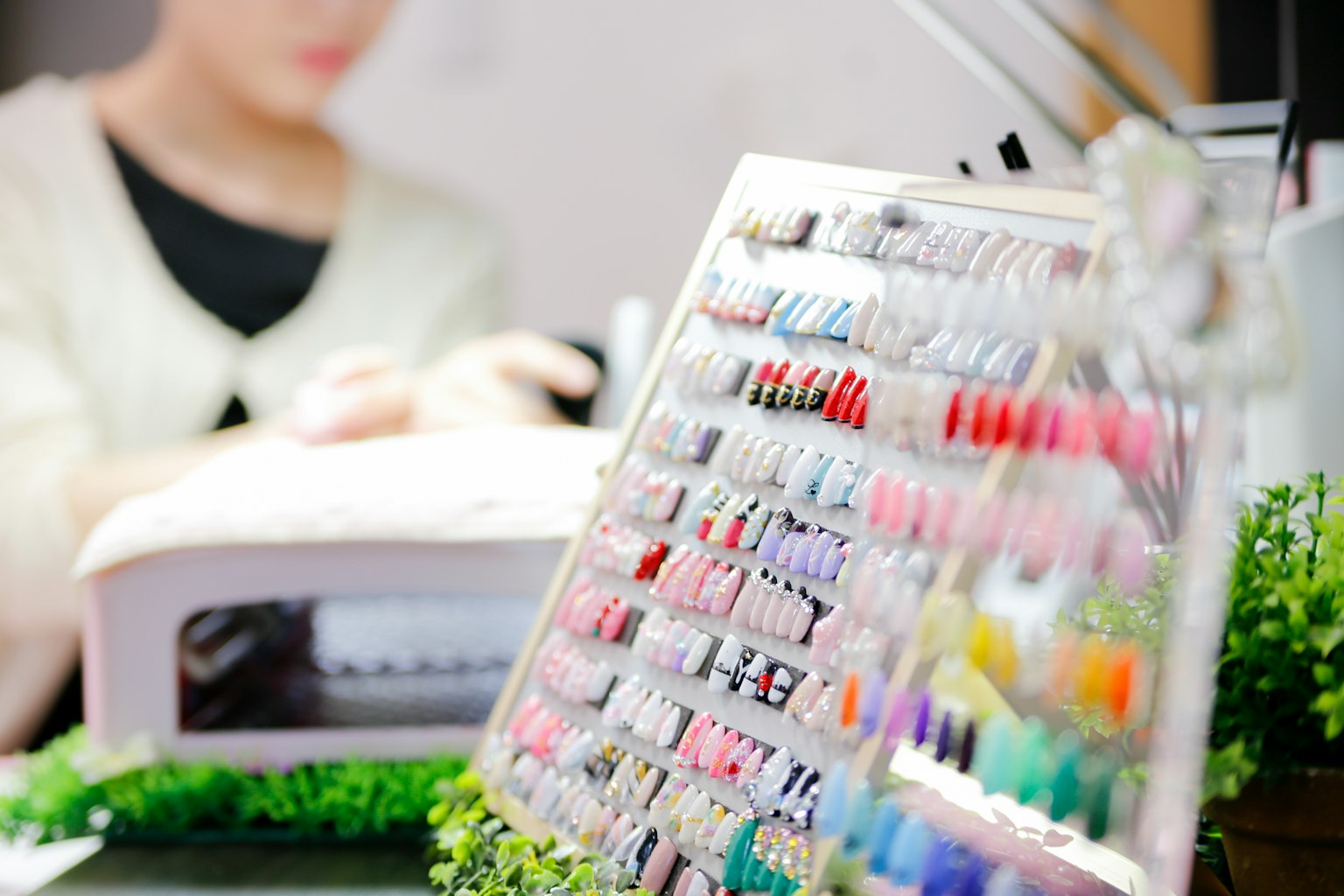 美甲店内色彩斑斓的指甲油展示，正在做指甲的女性