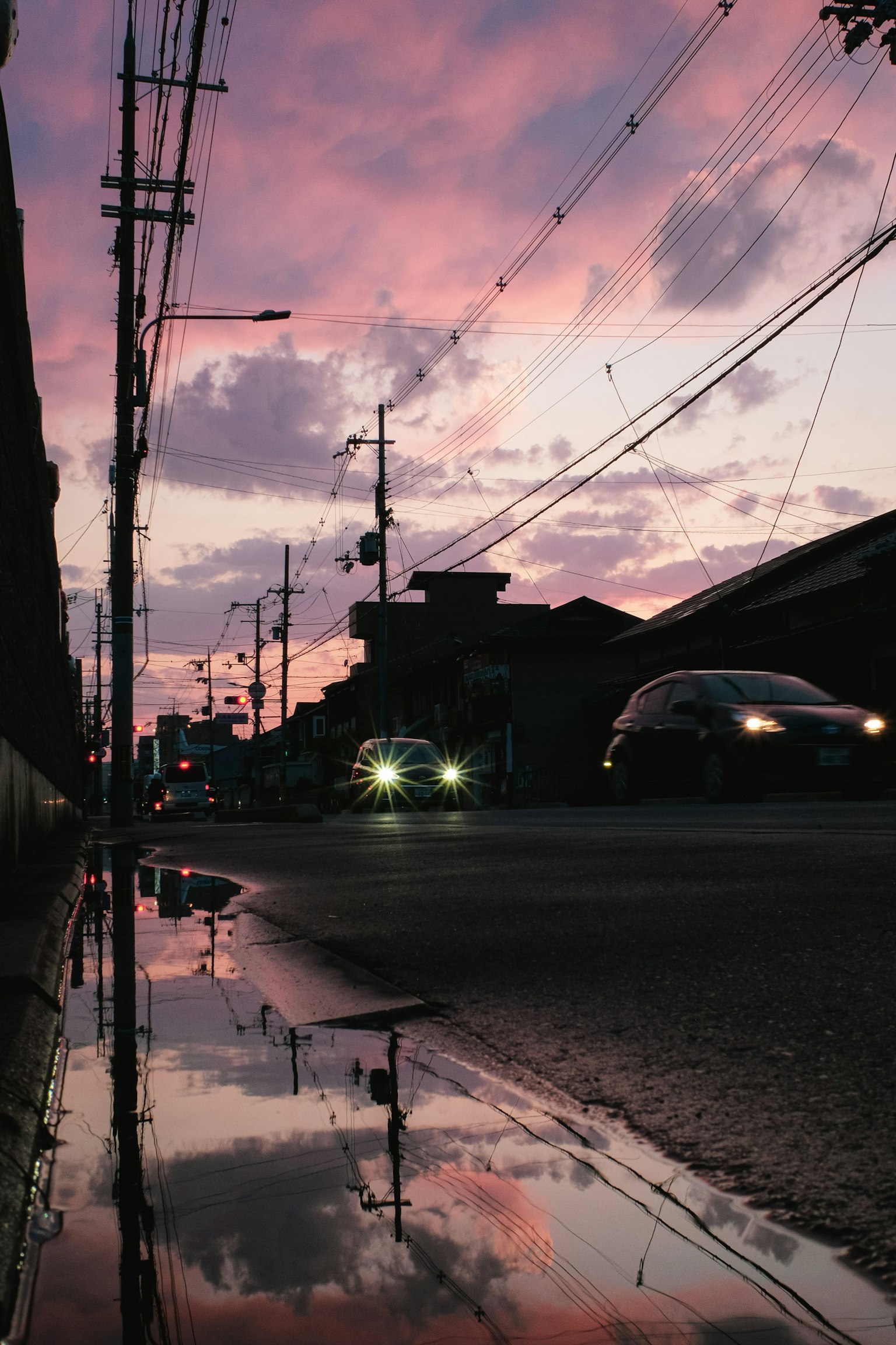 Bellissimo cielo al tramonto riflesso in una pozzanghera con paesaggio urbano