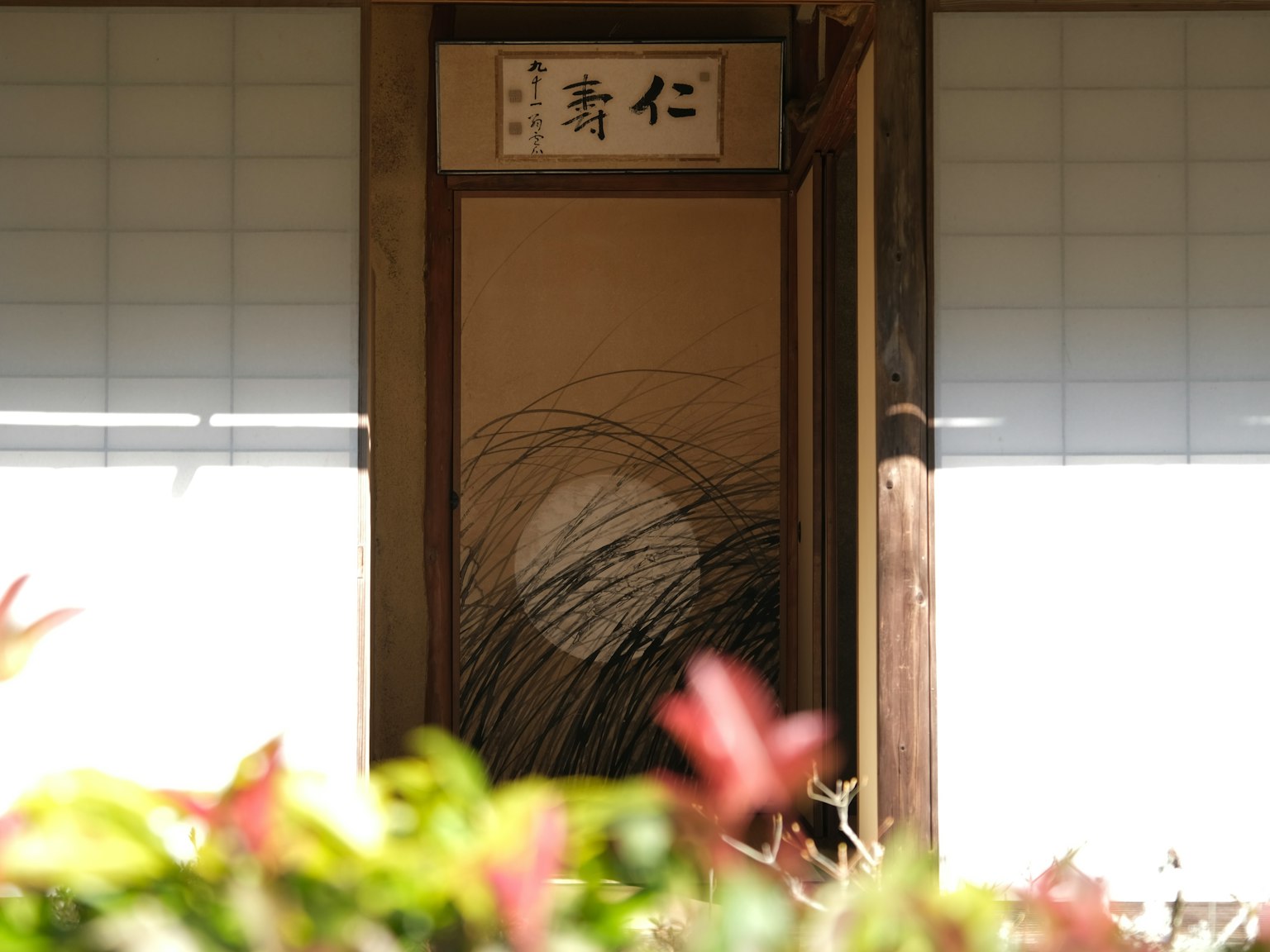Entrada de un edificio japonés tradicional con puerta de madera y shoji