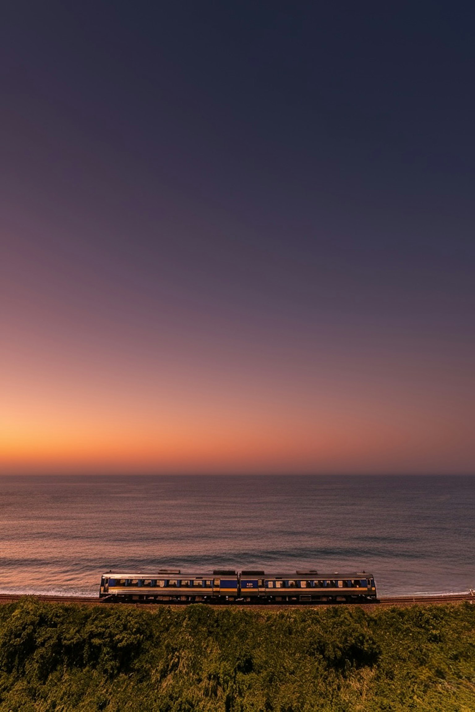 海岸線に沿って走る列車と美しい夕焼けの風景