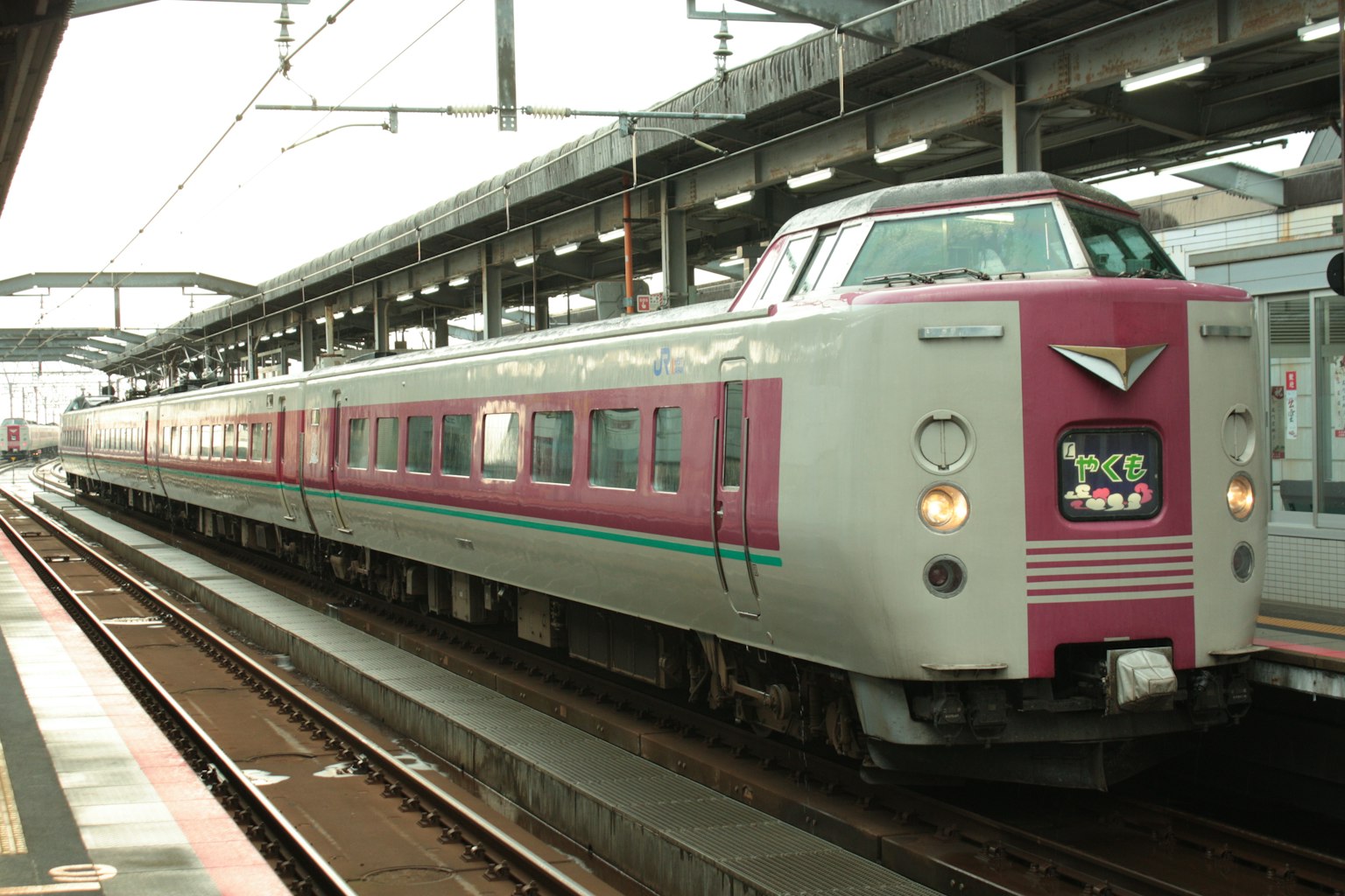 รถไฟด่วนญี่ปุ่นสีชมพูและเงินจอดอยู่ที่สถานี