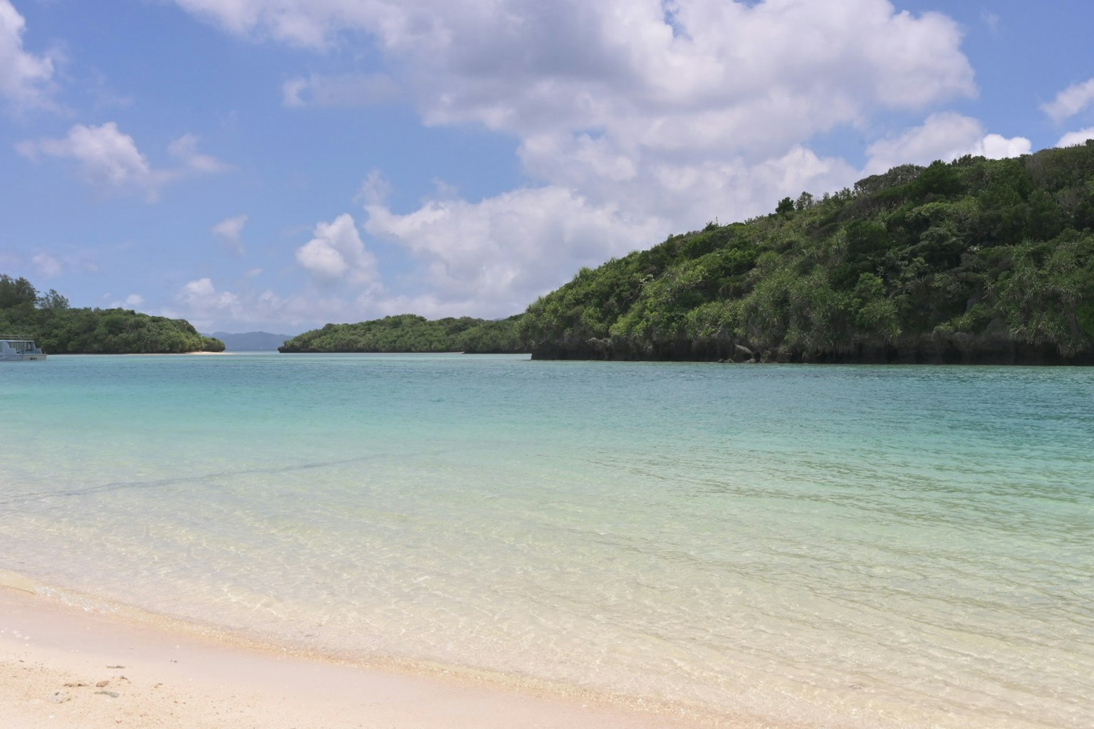Vista di spiaggia panoramica con acqua blu chiaro e sabbia bianca
