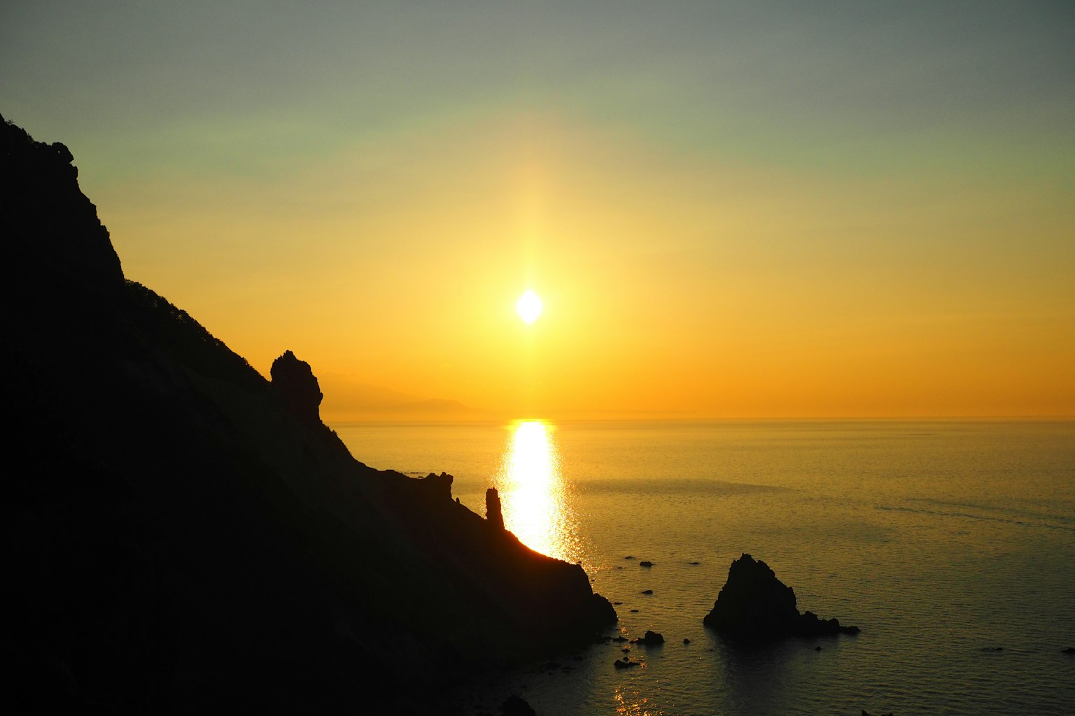 Beautiful sunset over the sea with mountain silhouettes