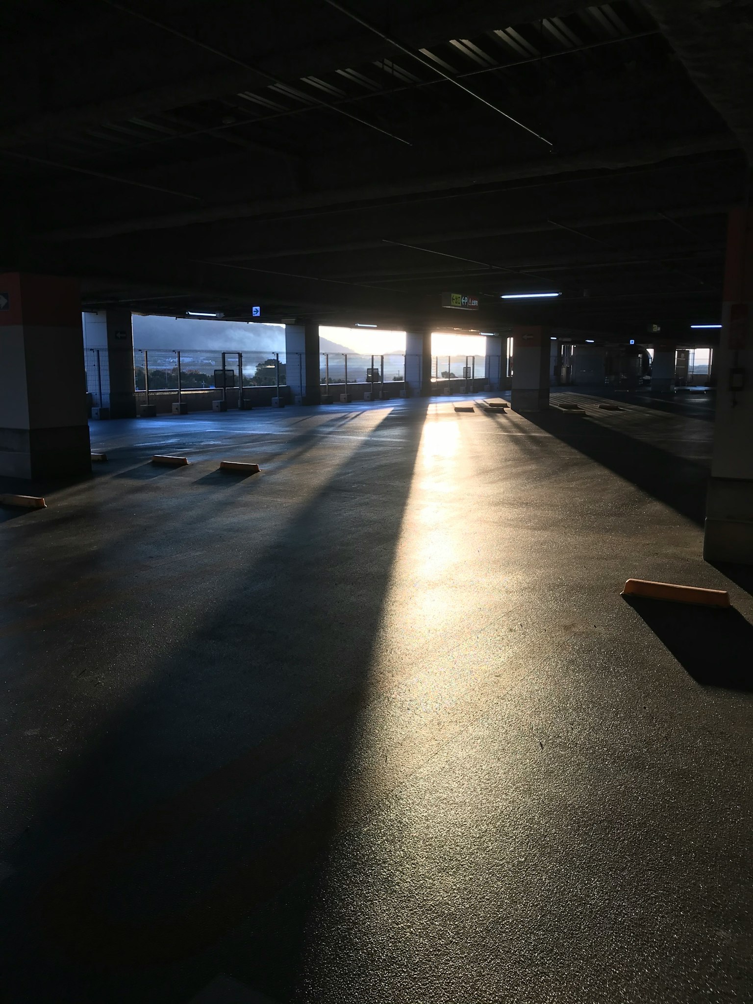 Intérieur d'un parking avec la lumière du soleil entrant et des ombres contrastées