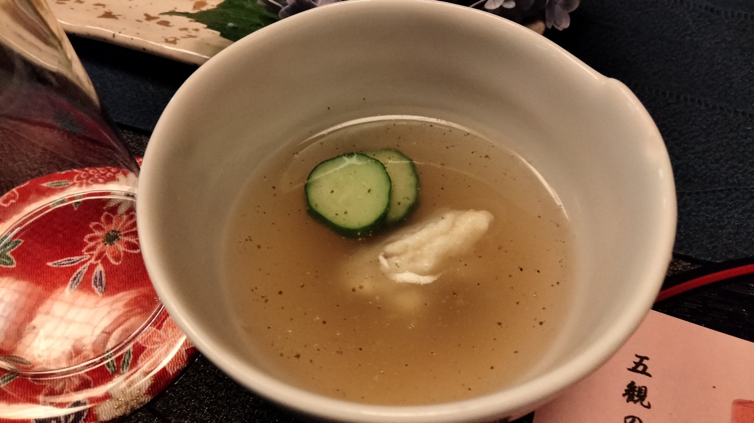 Soupe claire avec des tranches de concombre flottant dans un plat japonais traditionnel