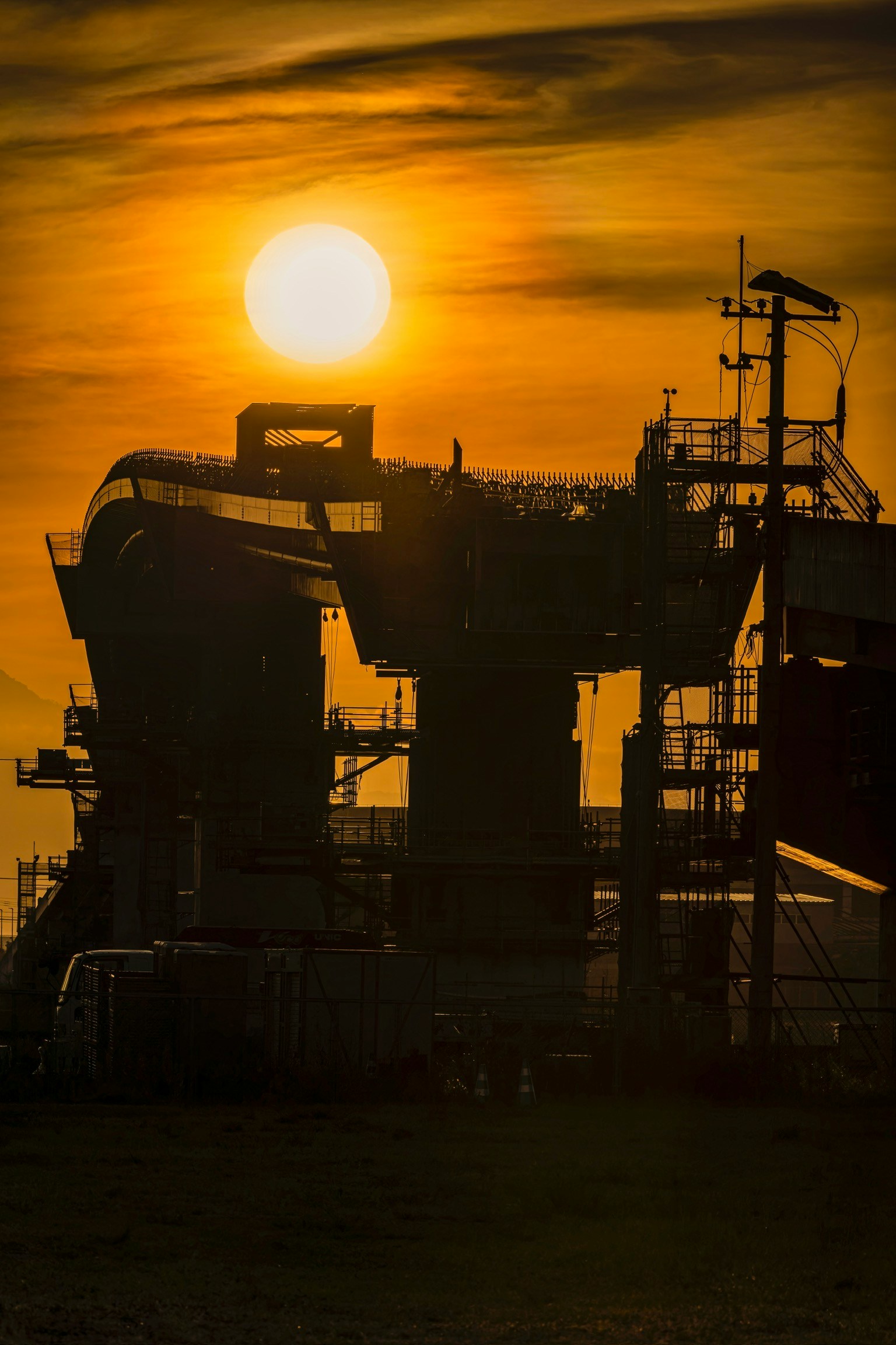 Silhouette of industrial structures against the sunset