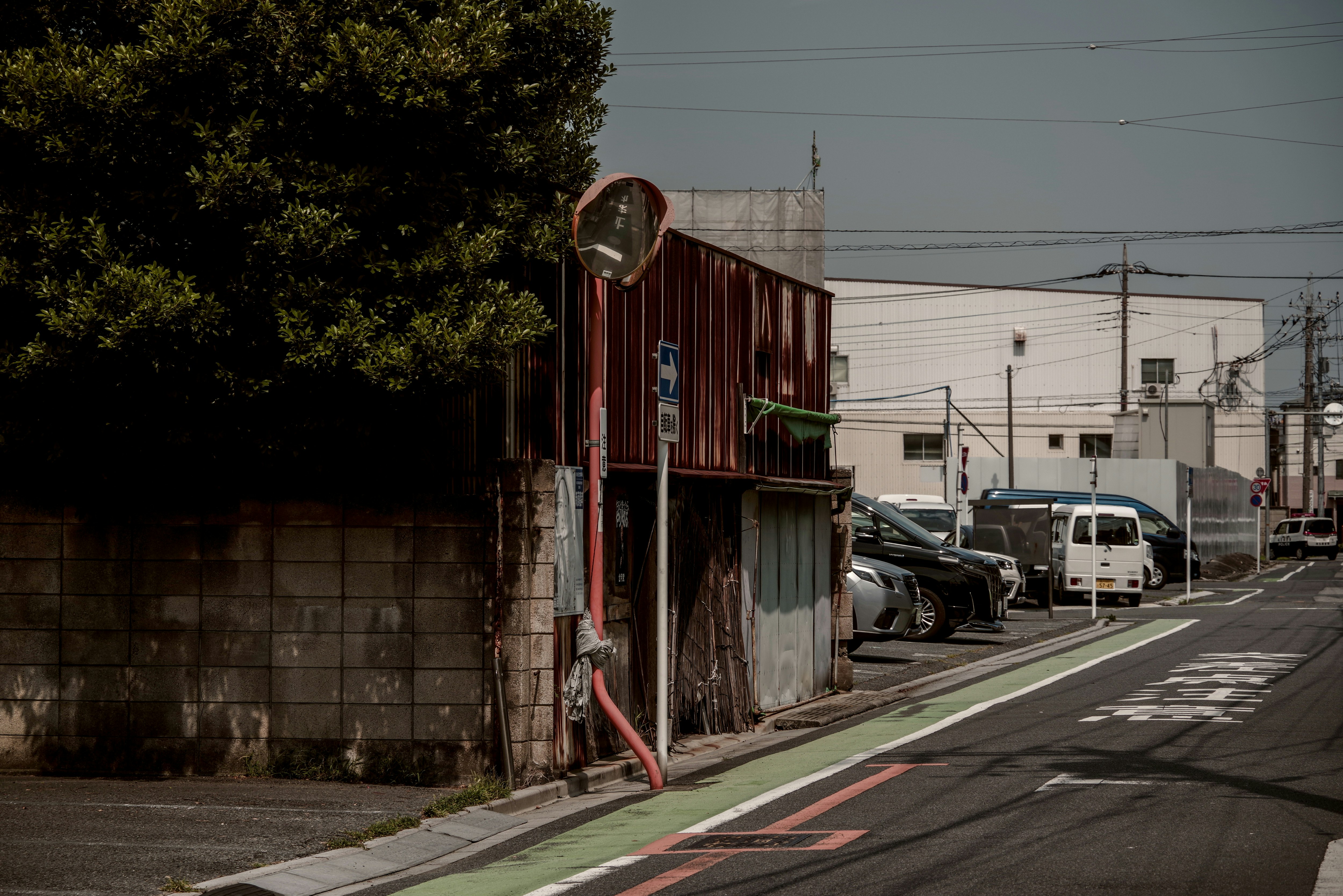 西川口の路地に並ぶ車と工場の外壁
