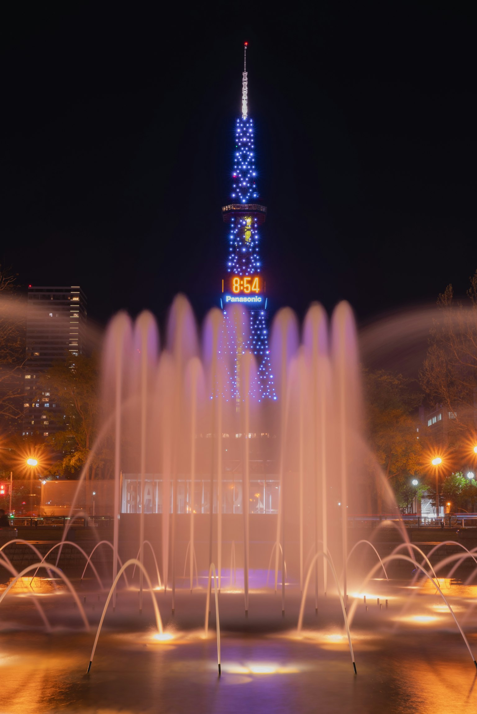 夜间照亮的名古屋电视塔与五彩缤纷的喷泉