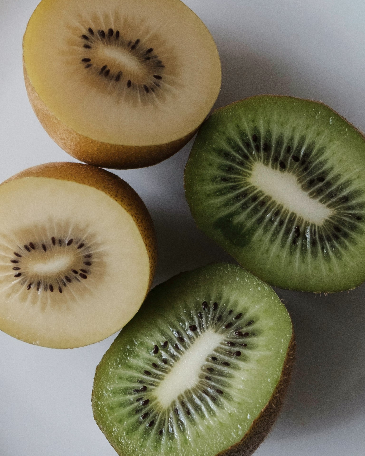 Bild zeigt Querschnitte von Kiwi mit gelben und grünen Sorten