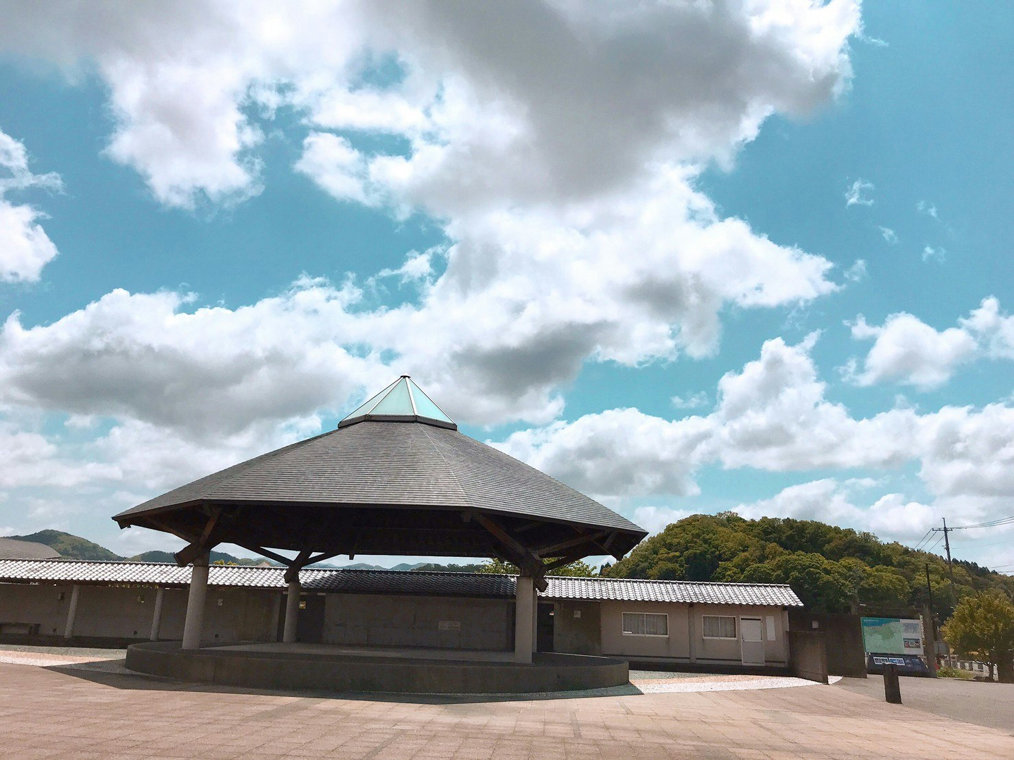 Outdoor circular pavilion and plaza under a cloudy sky