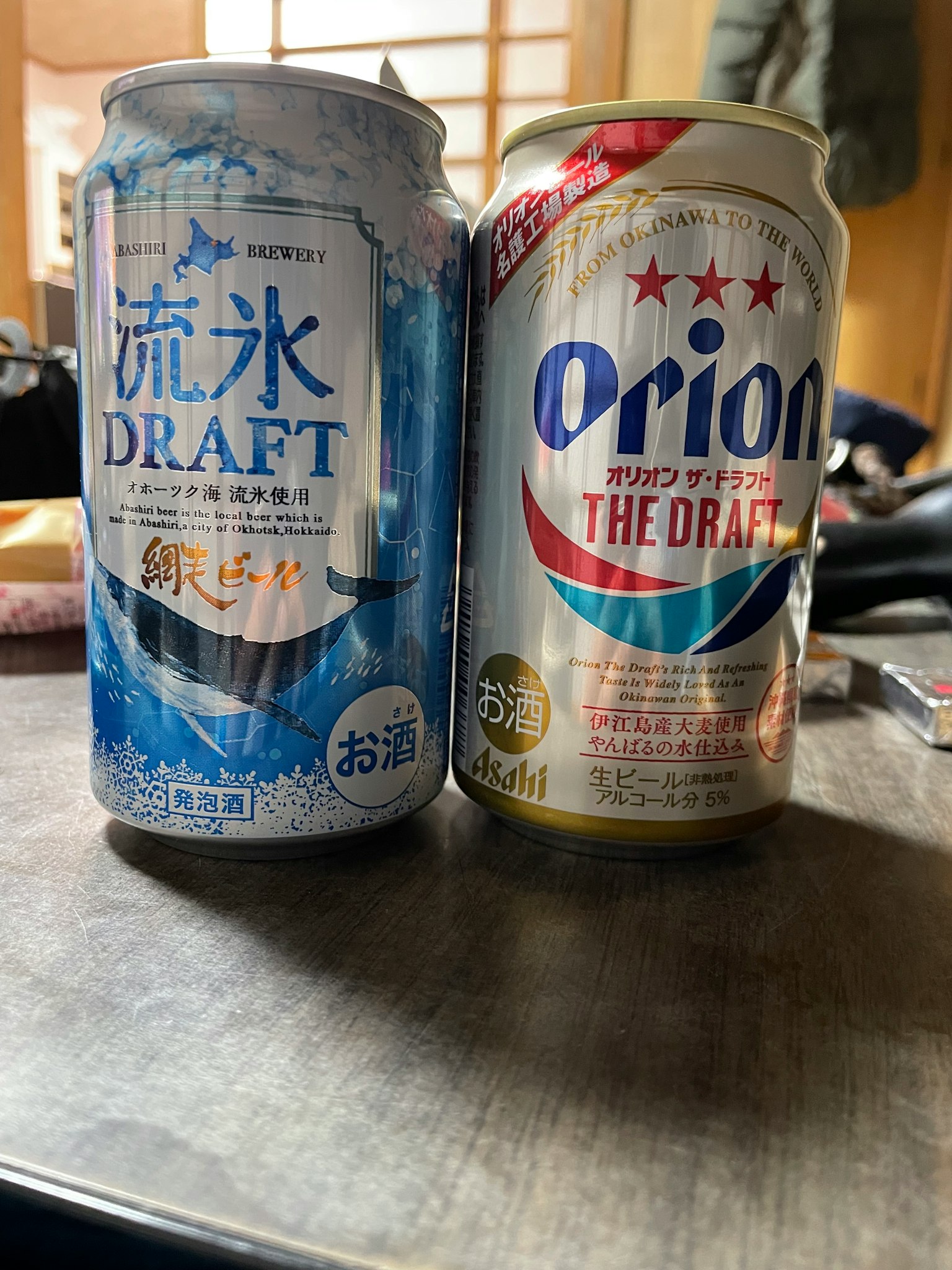 两罐啤酒，分别是流冰啤酒和奥利安啤酒