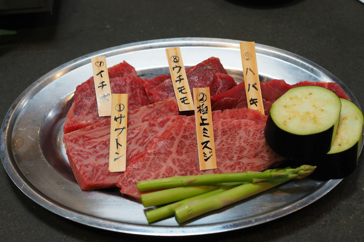 Plato de carnes variadas con etiquetas y verduras