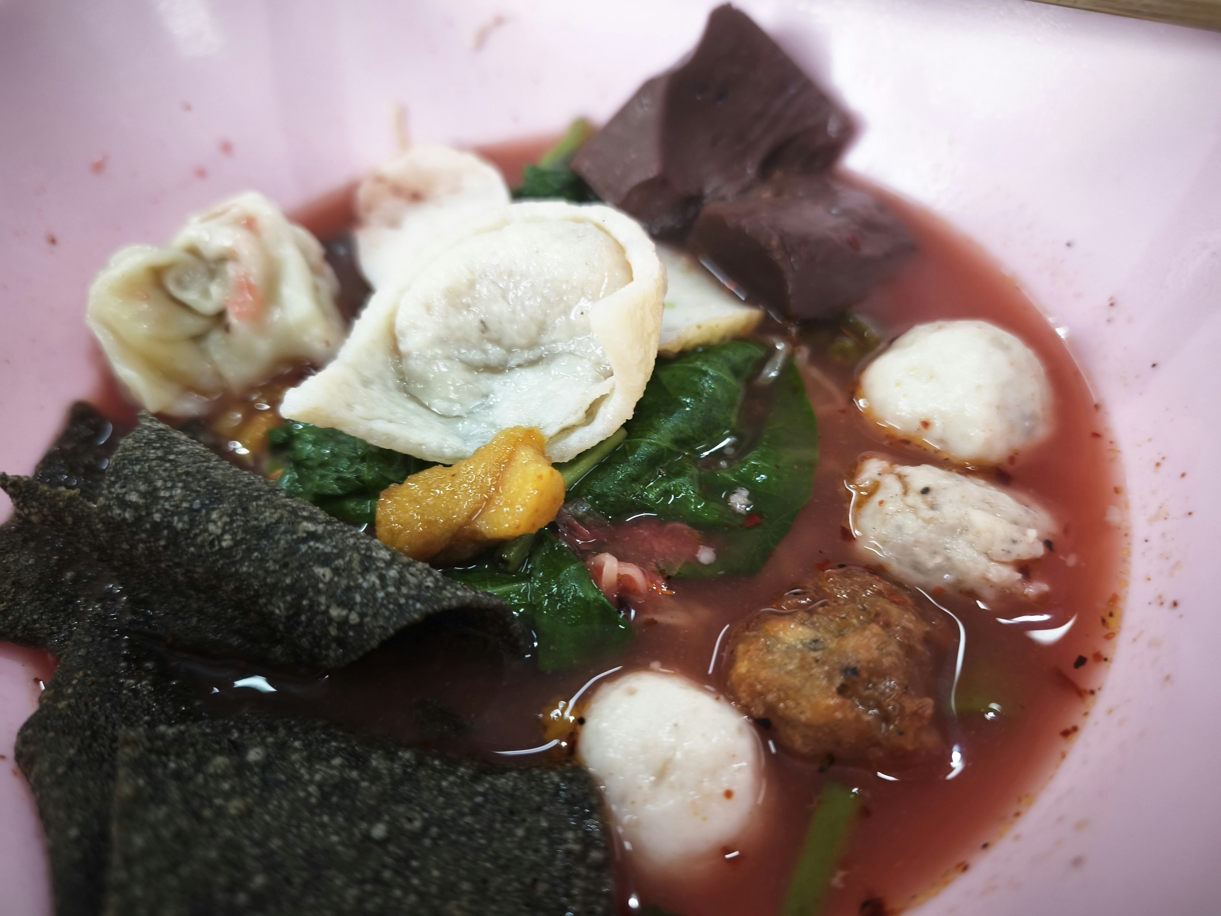 赤いスープに浮かぶ餃子・野菜とソーセージ