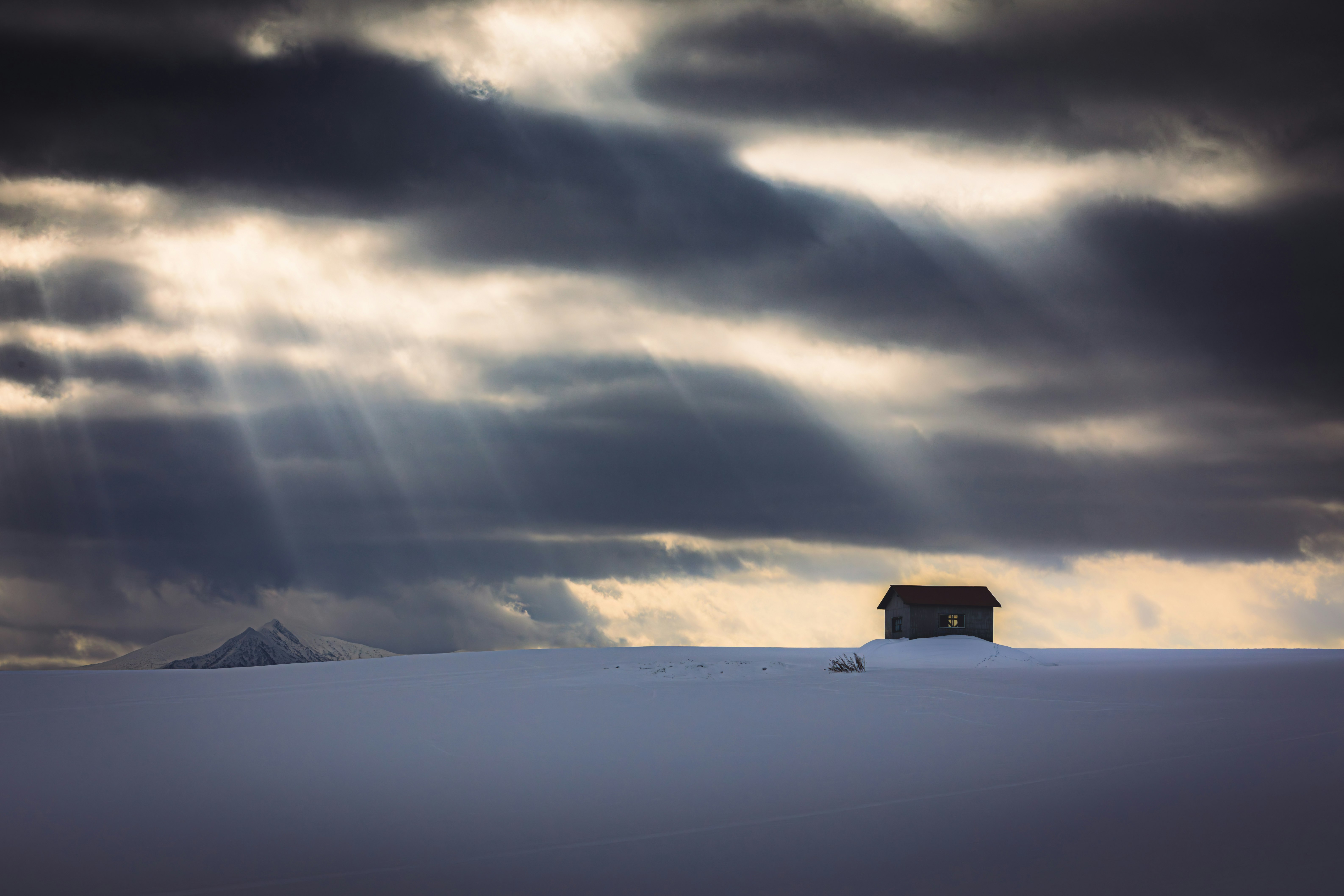 雪地裡的小屋與戲劇性的雲層