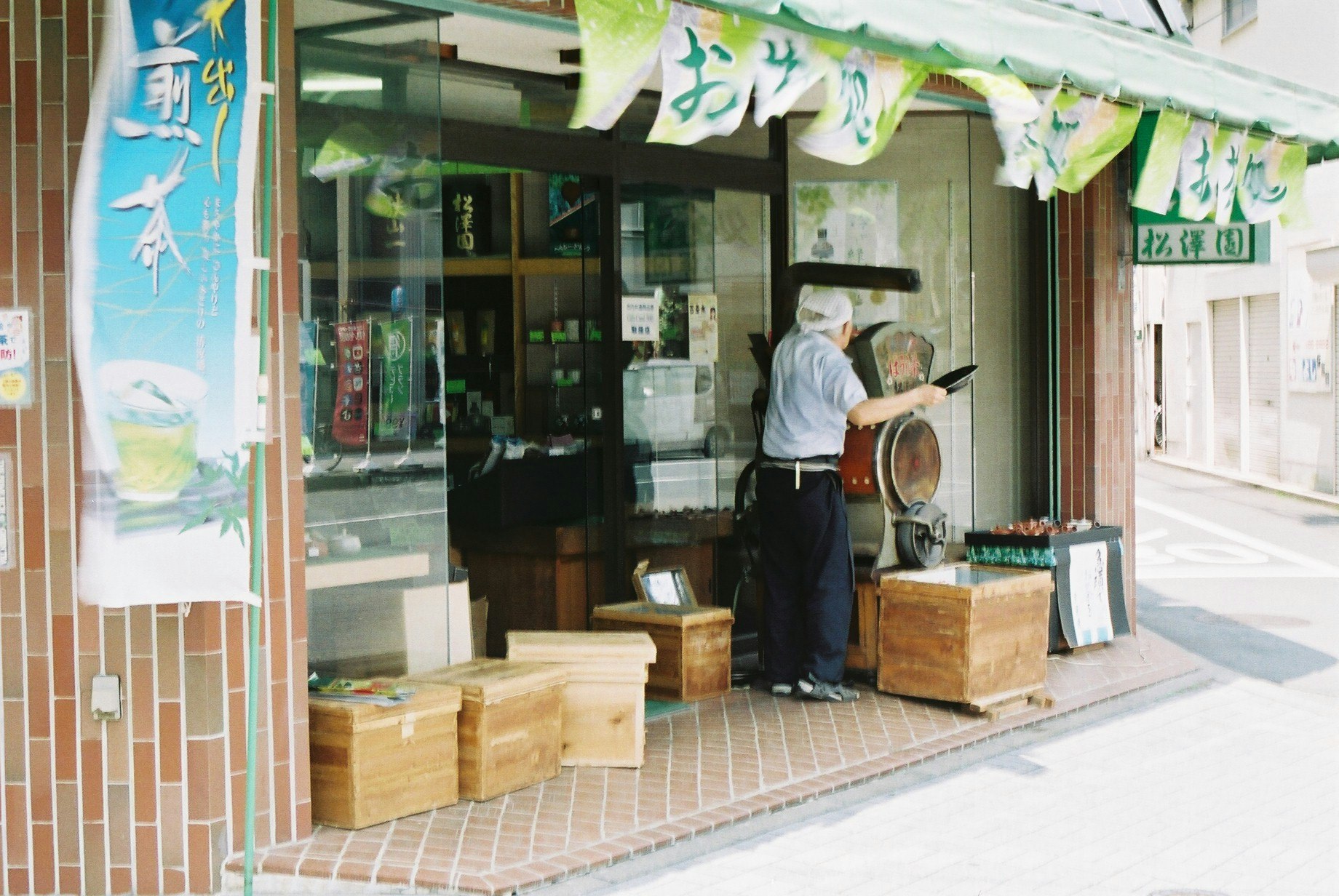 路地の軒先に並ぶ木箱と店頭の屋台