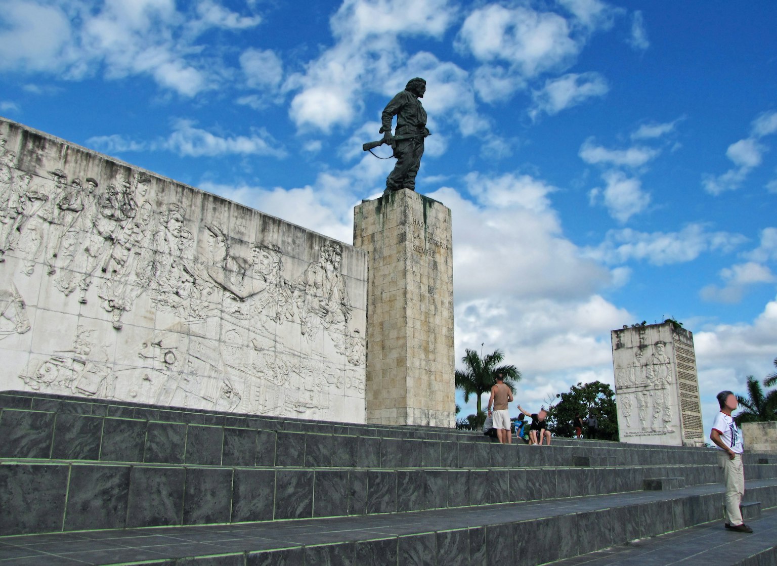 Kriegerstatue steht unter blauem Himmel mit Menschen in der Nähe