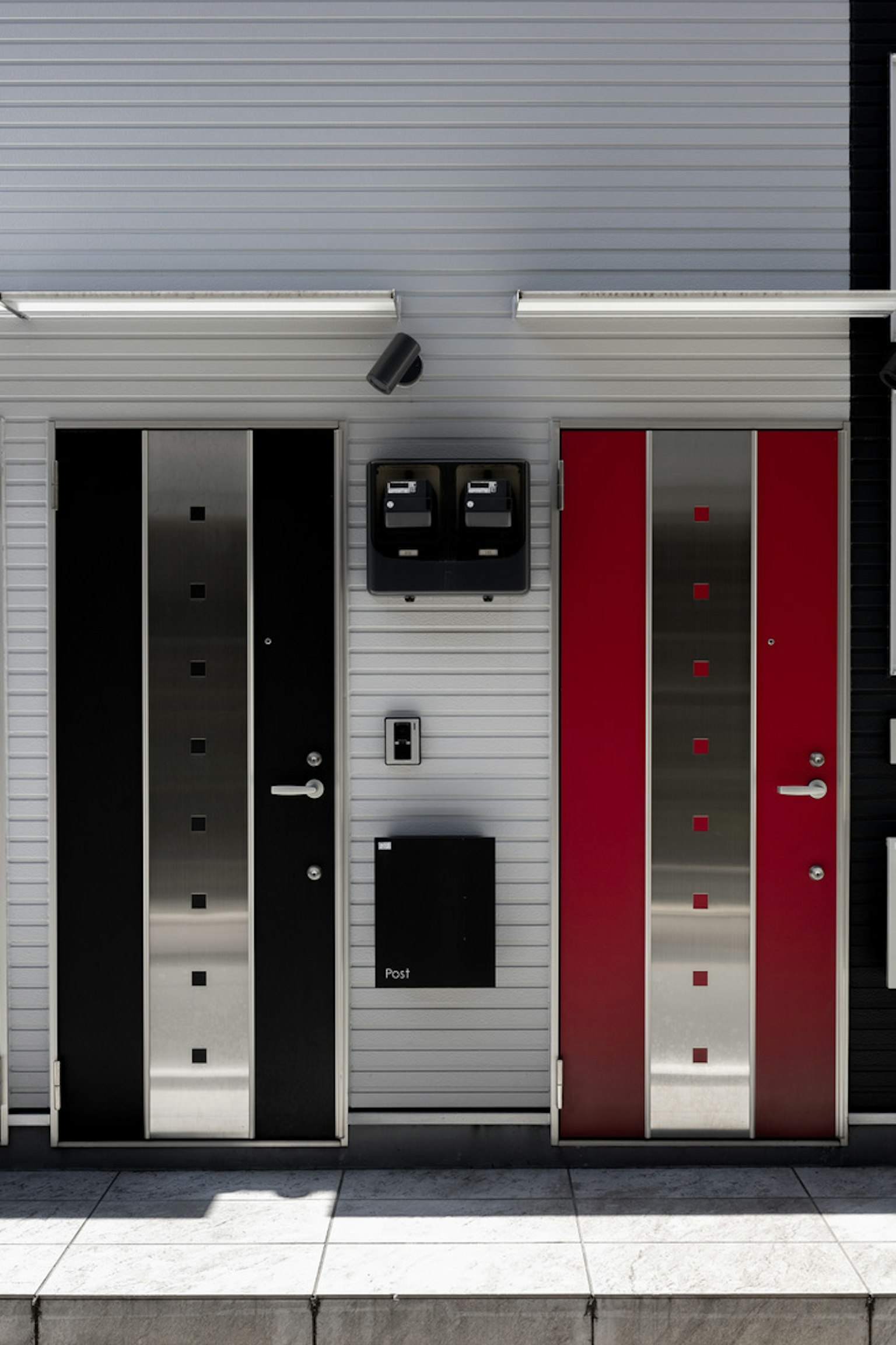 Modern building facade featuring black and red doors