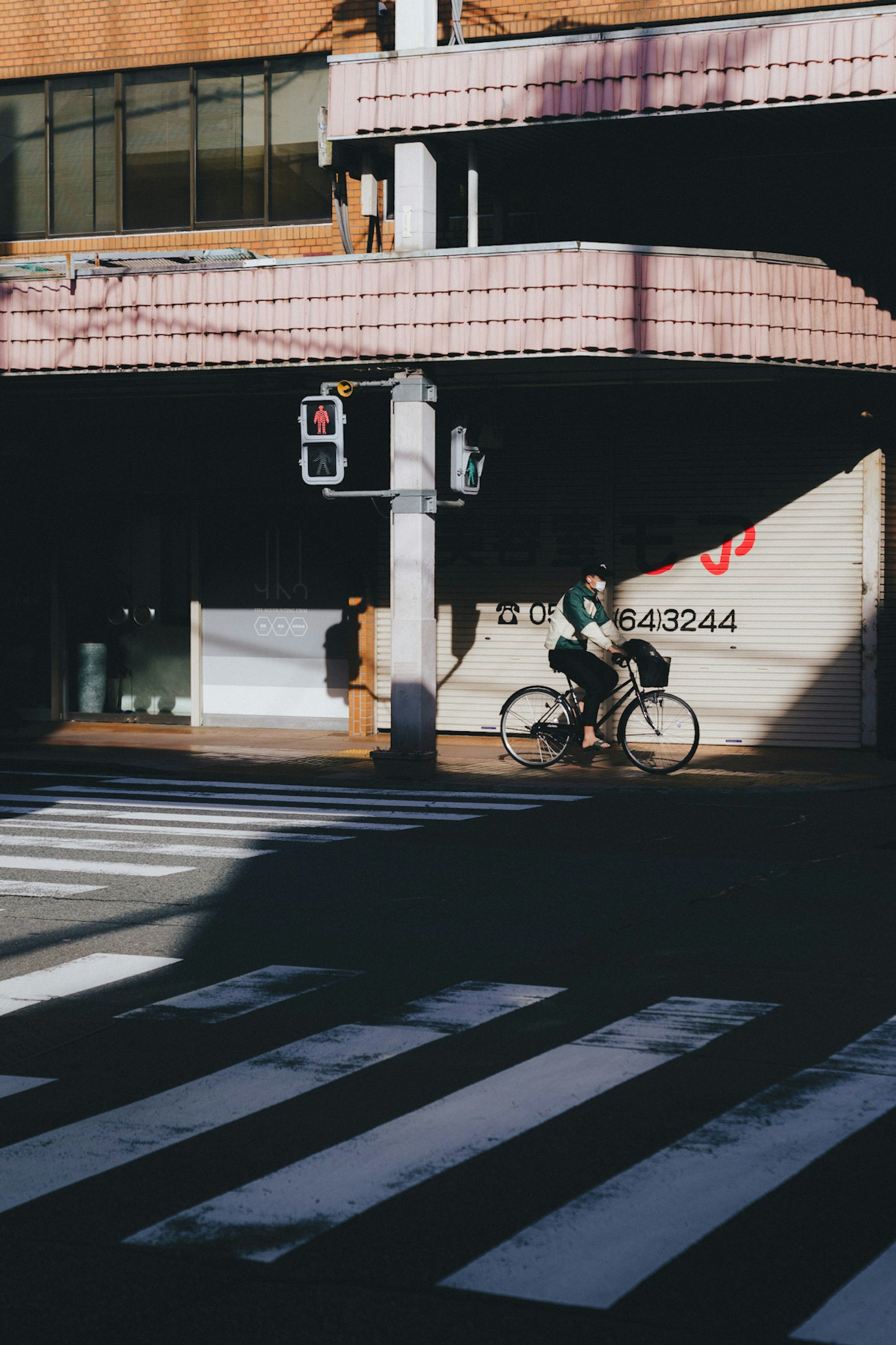 A person riding a bicycle near a crosswalk with urban elements