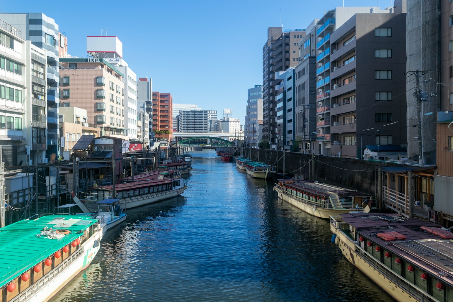 Vista de un canal en Tokio rodeado de edificios y botes