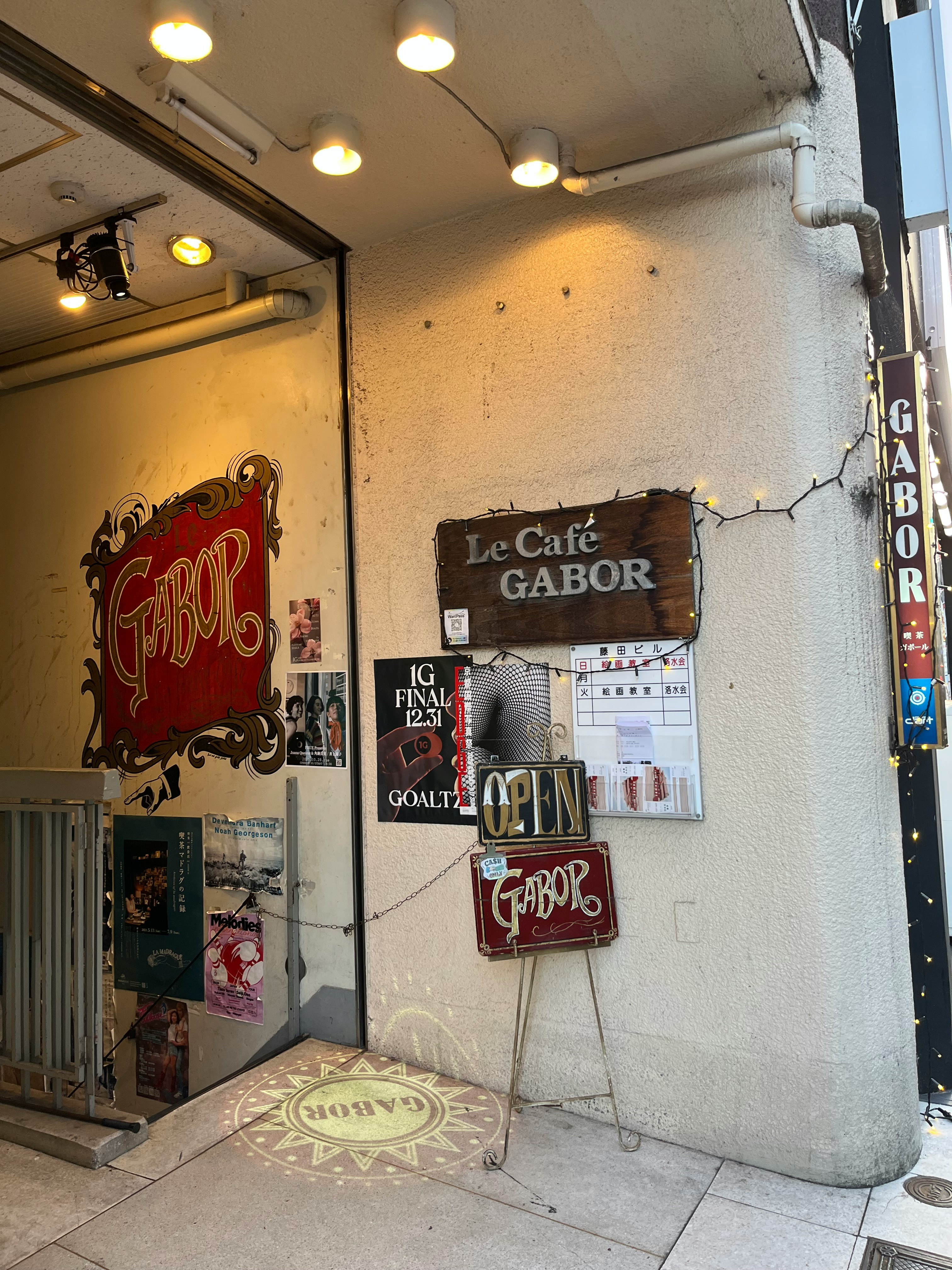 壁に掲げられた看板と店先の小さな装飾がある路地の入口