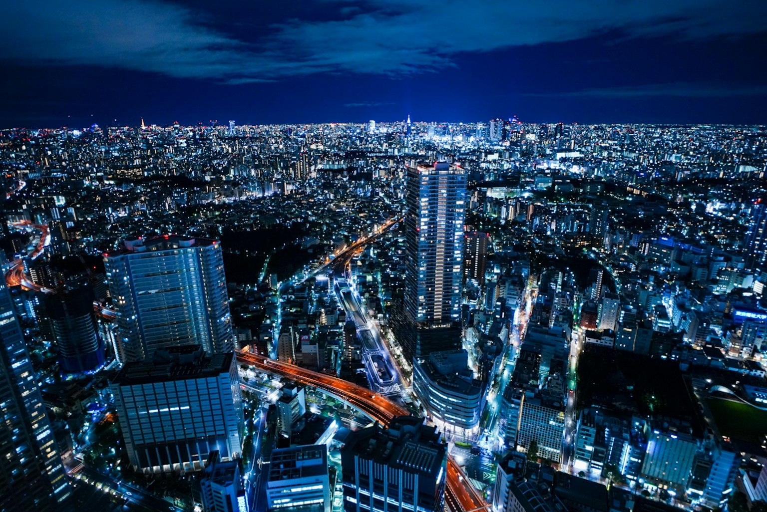 Cielo nocturno de Tokio con rascacielos iluminados y luces de la ciudad vibrantes