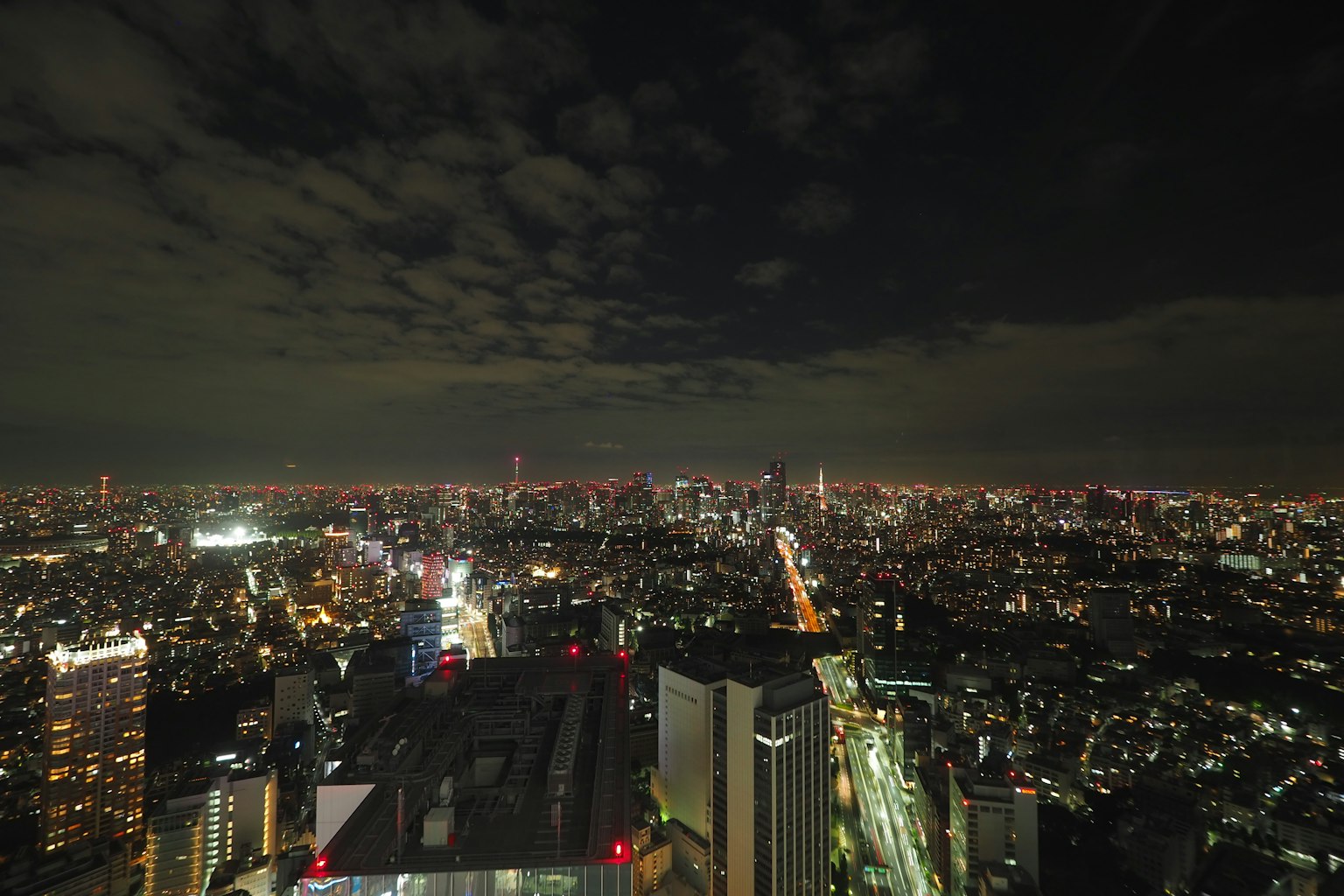 Panoramic view of Tokyo skyline at night with illuminated skyscrapers