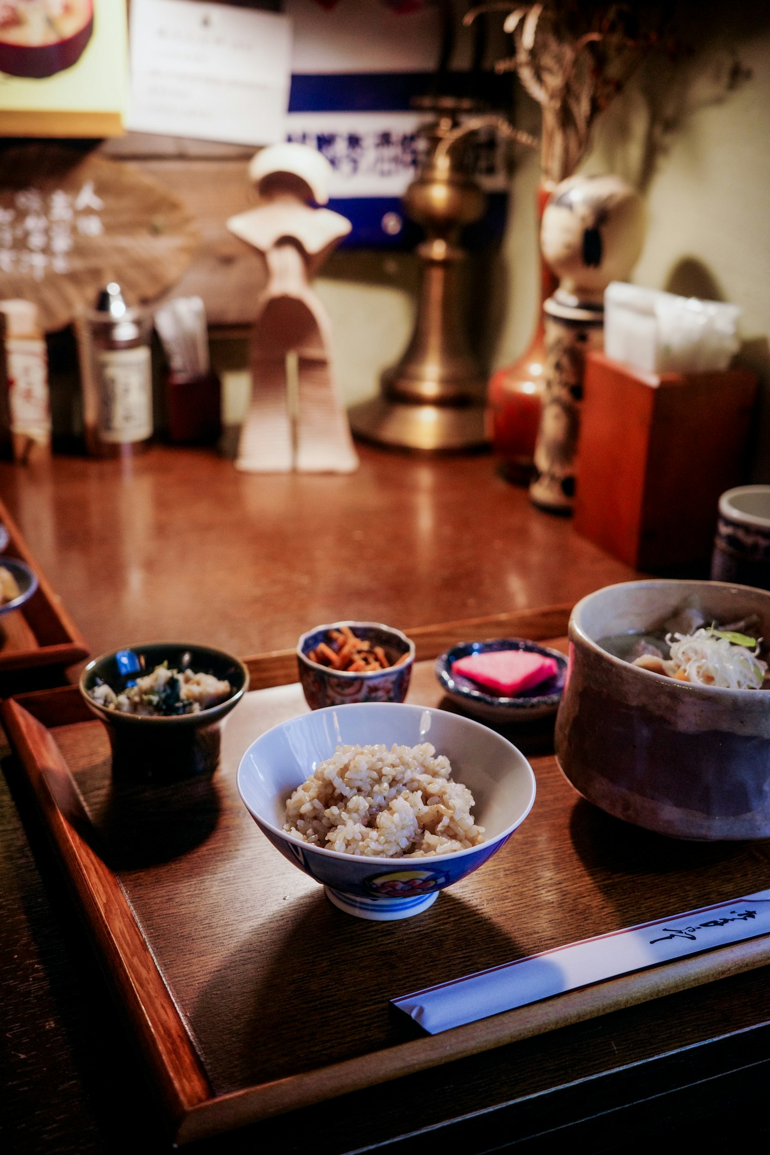 Repas japonais servi sur un plateau en bois avec du riz et des petits plats