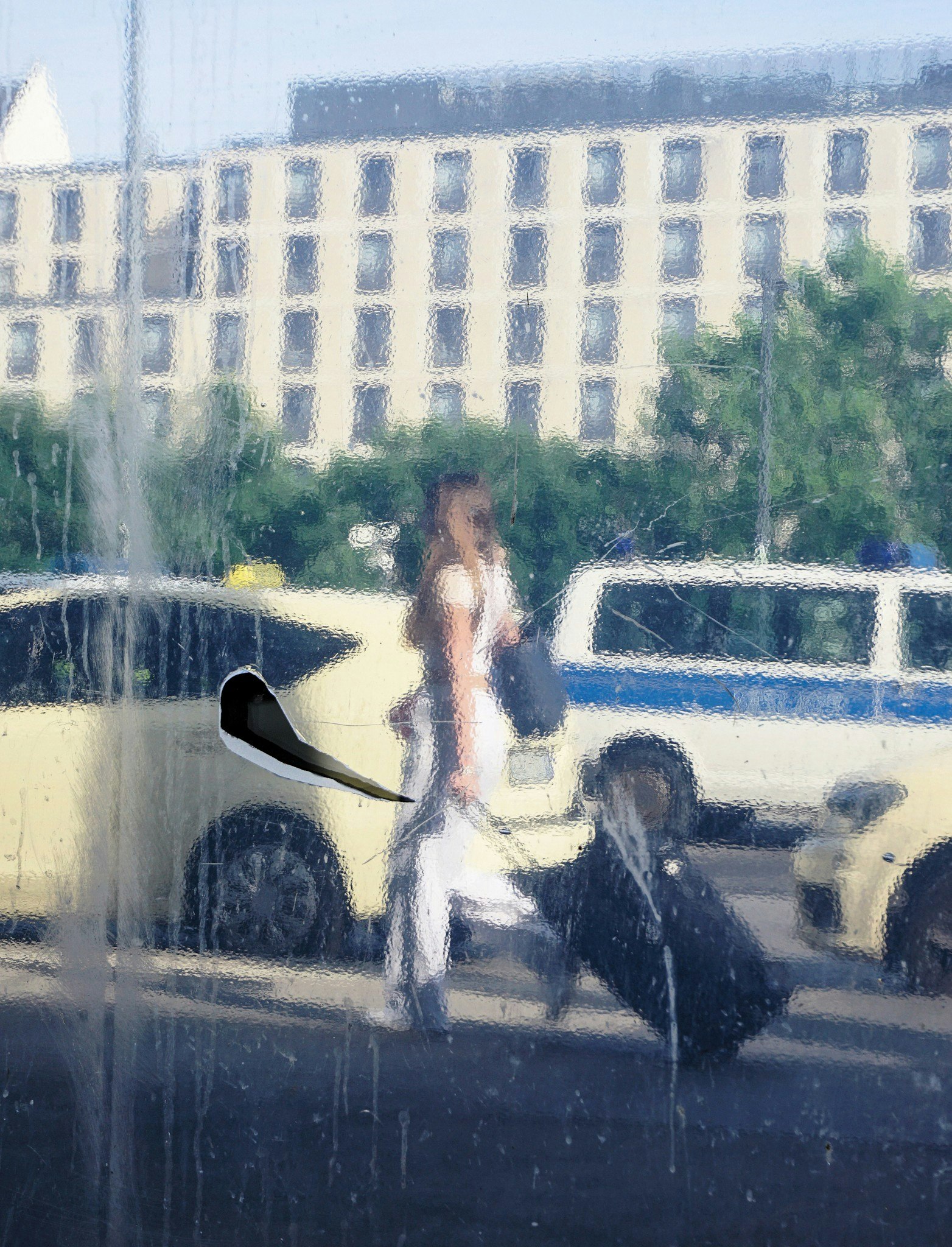 噴水の前を歩く女性の後ろ姿