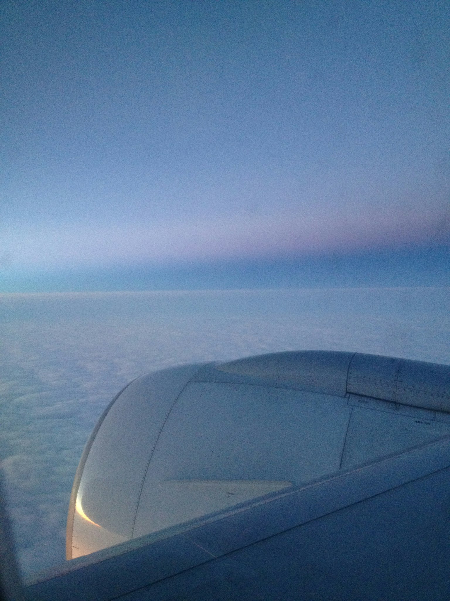 Blick aus einem Flugzeugfenster auf den blauen Himmel und die weißen Wolken