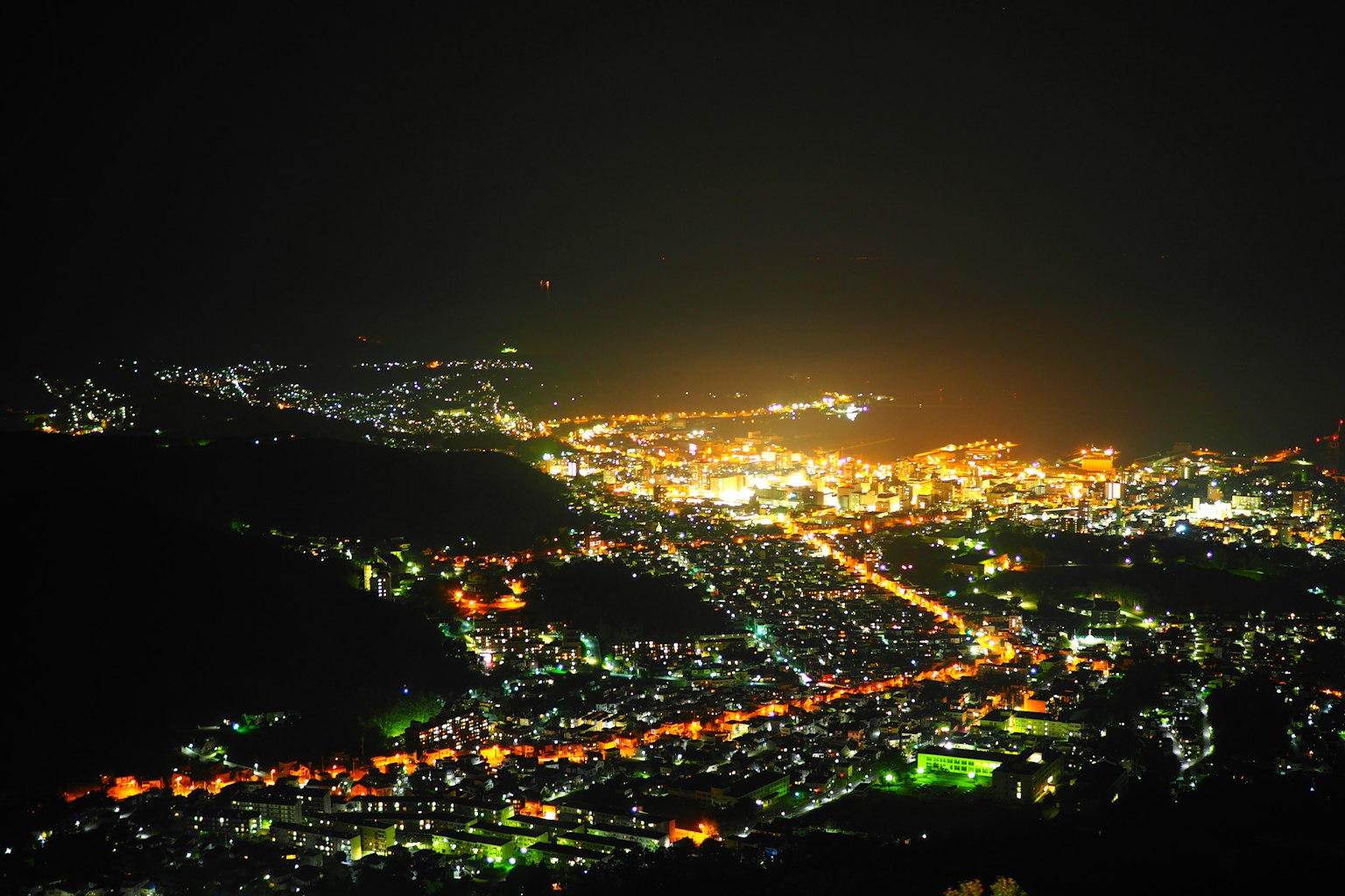 Pemandangan panorama indah kota di malam hari dengan lampu jalan dan gedung yang menyala