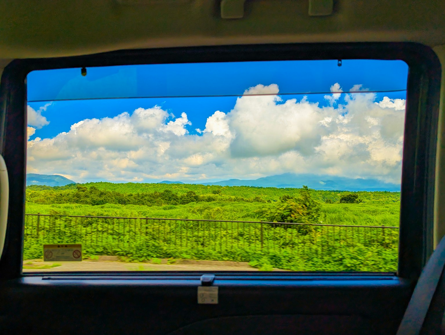 차 창문을 통해 보이는 푸른 풍경과 하늘