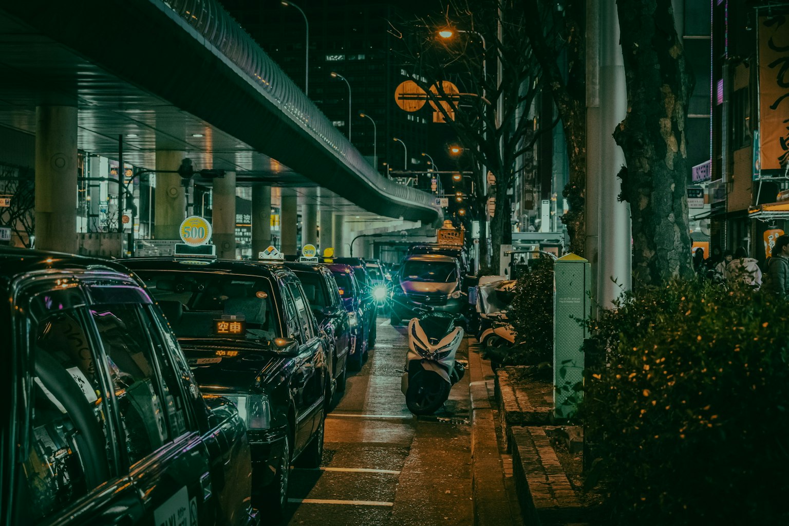 夜晚城市街道上的計程車和摩托車
